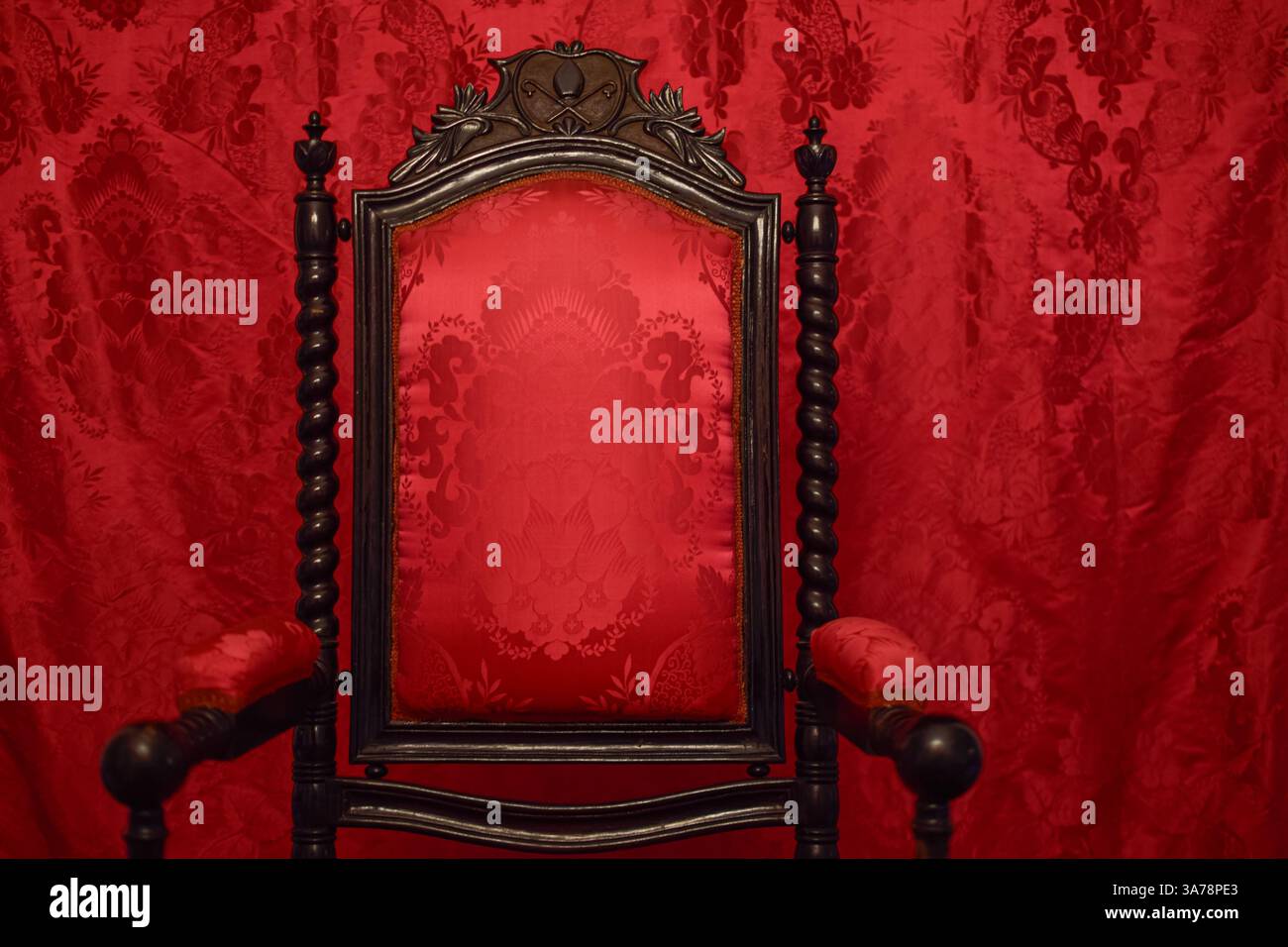 Trono Rosso medievale esposto con sfondo rosso velluto. Segovia, Spagna. Foto Stock