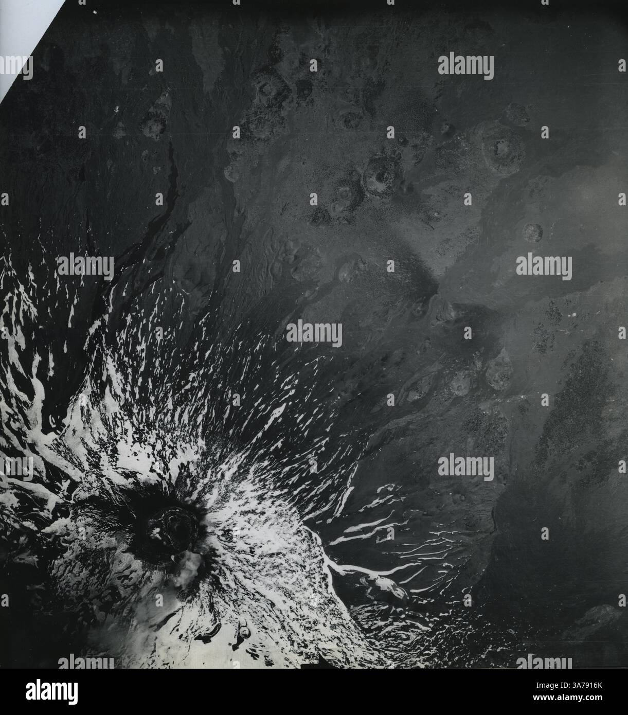Una drammatica immagine topografica aerea dell'Etna, l'iconico stratovulcano siciliano, catturato da un aereo da ricognizione militare statunitense nell'Italia del dopoguerra. Scattata alla fine degli anni '1940, la fotografia rivela flussi lavici ricoperti di neve e fessure radiali che scendono dal cratere sommitale. Questa immagine è stata utilizzata in indagini geologiche per valutare l'attività vulcanica e il terreno sulla scia della seconda guerra mondiale Foto Stock