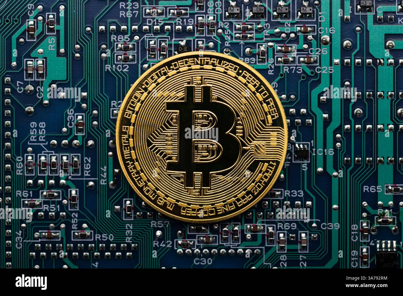 Moneda dorada Bitcoin en una placa de circuito electrónico de ordenador Foto Stock