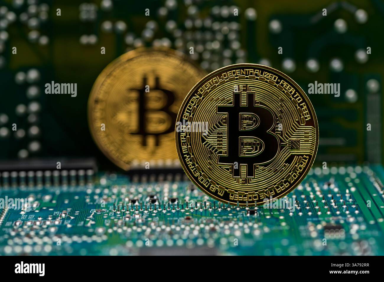 Moneda dorada Bitcoin en una placa de circuito electrónico de ordenador Foto Stock
