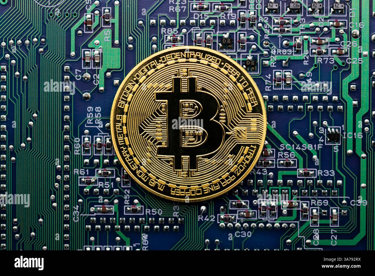 Moneda dorada Bitcoin en una placa de circuito electrónico de ordenador Foto Stock
