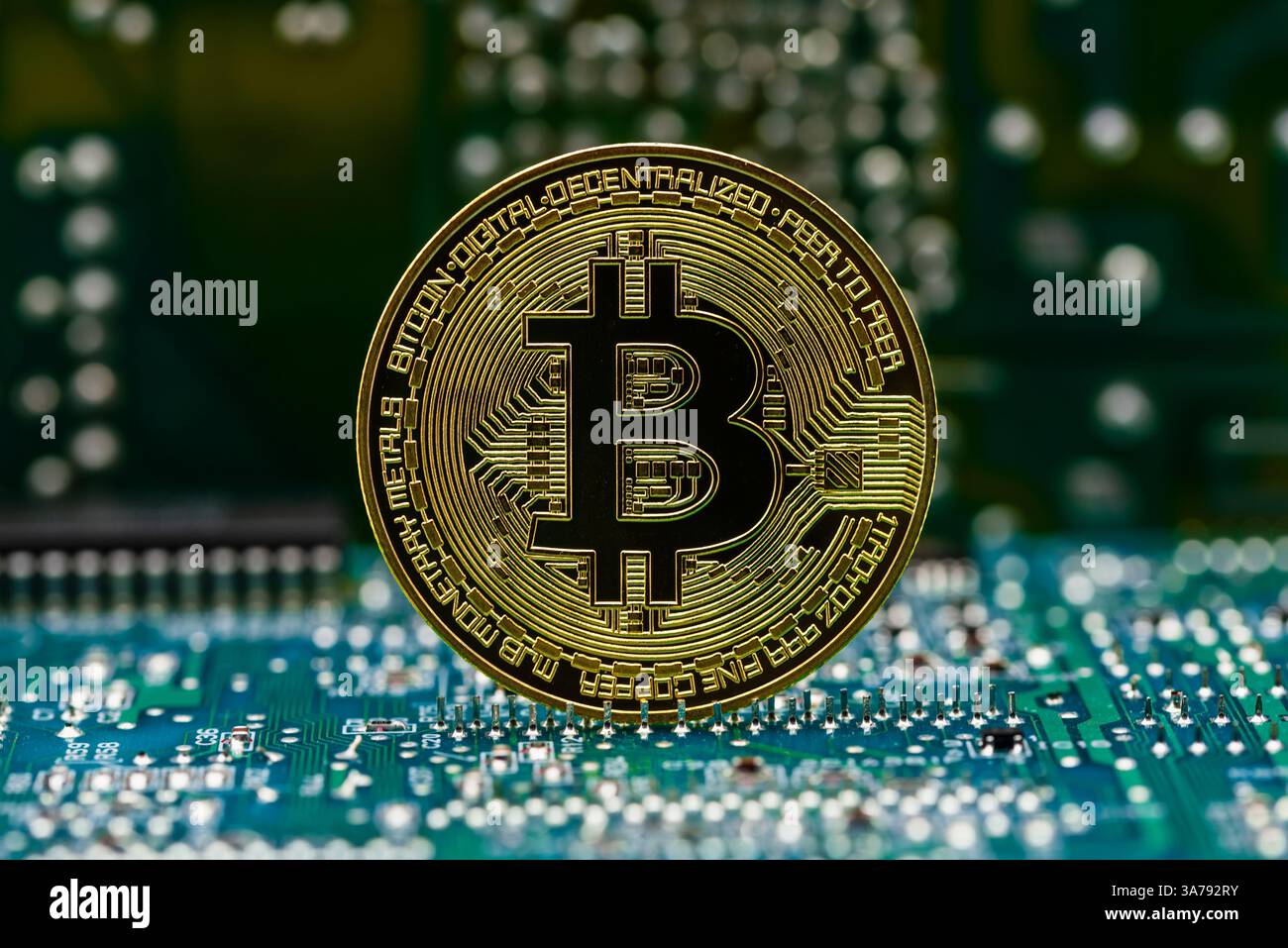 Moneda dorada Bitcoin en una placa de circuito electrónico de ordenador Foto Stock