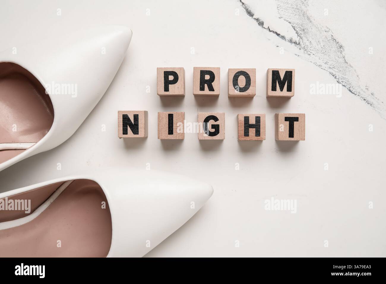 Cubi con testo PROM NOTTE e tacchi alti su sfondo in marmo bianco Foto Stock