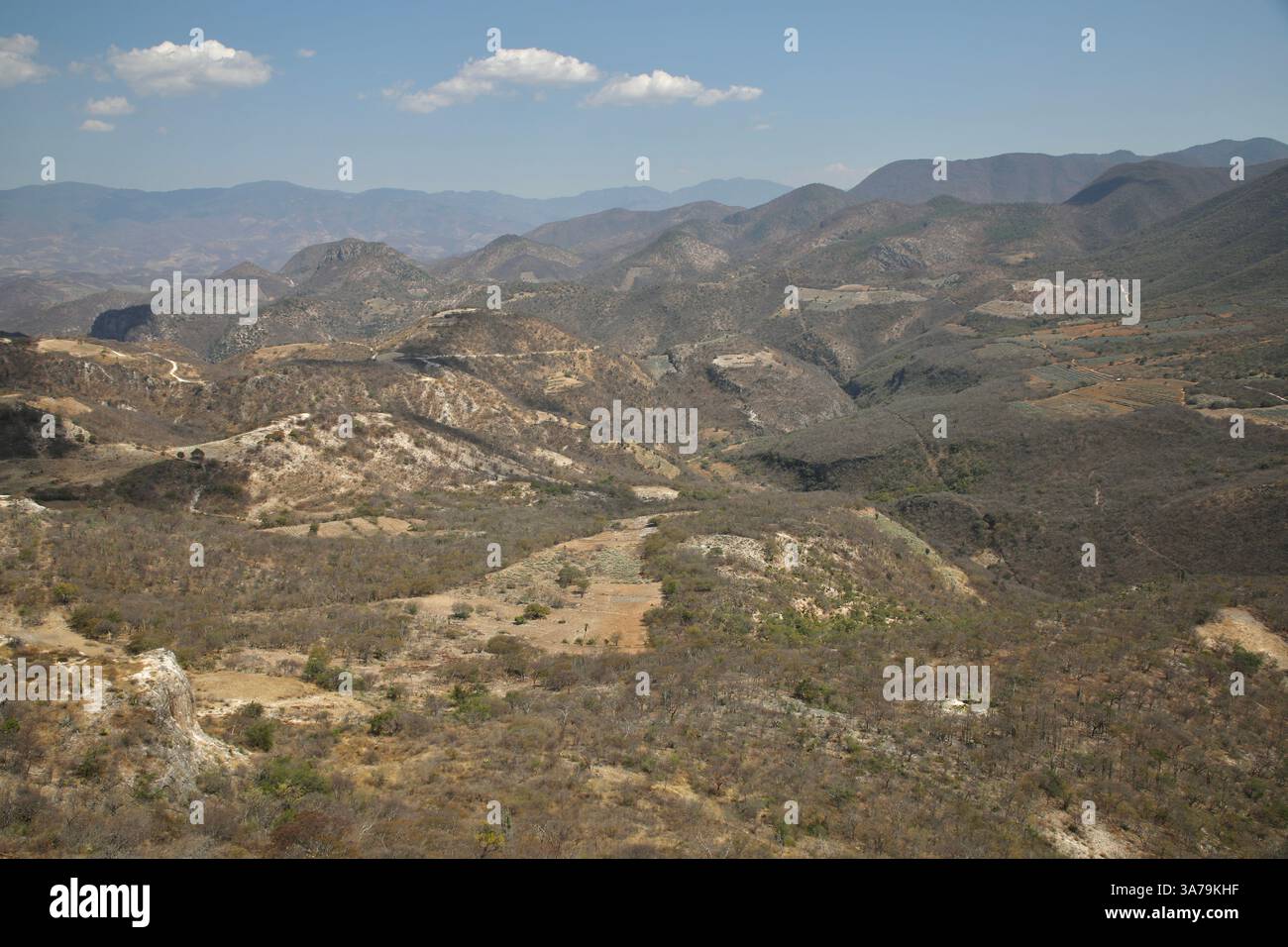Le montagne che circondano Hierve el Agua, una formazione geologica sono raffigurate. Hierve el Agua è costituita da due cascate pietrificate bianche create da sorgenti la cui acqua è supersaturata con carbonato di calcio e altri minerali. Foto Stock