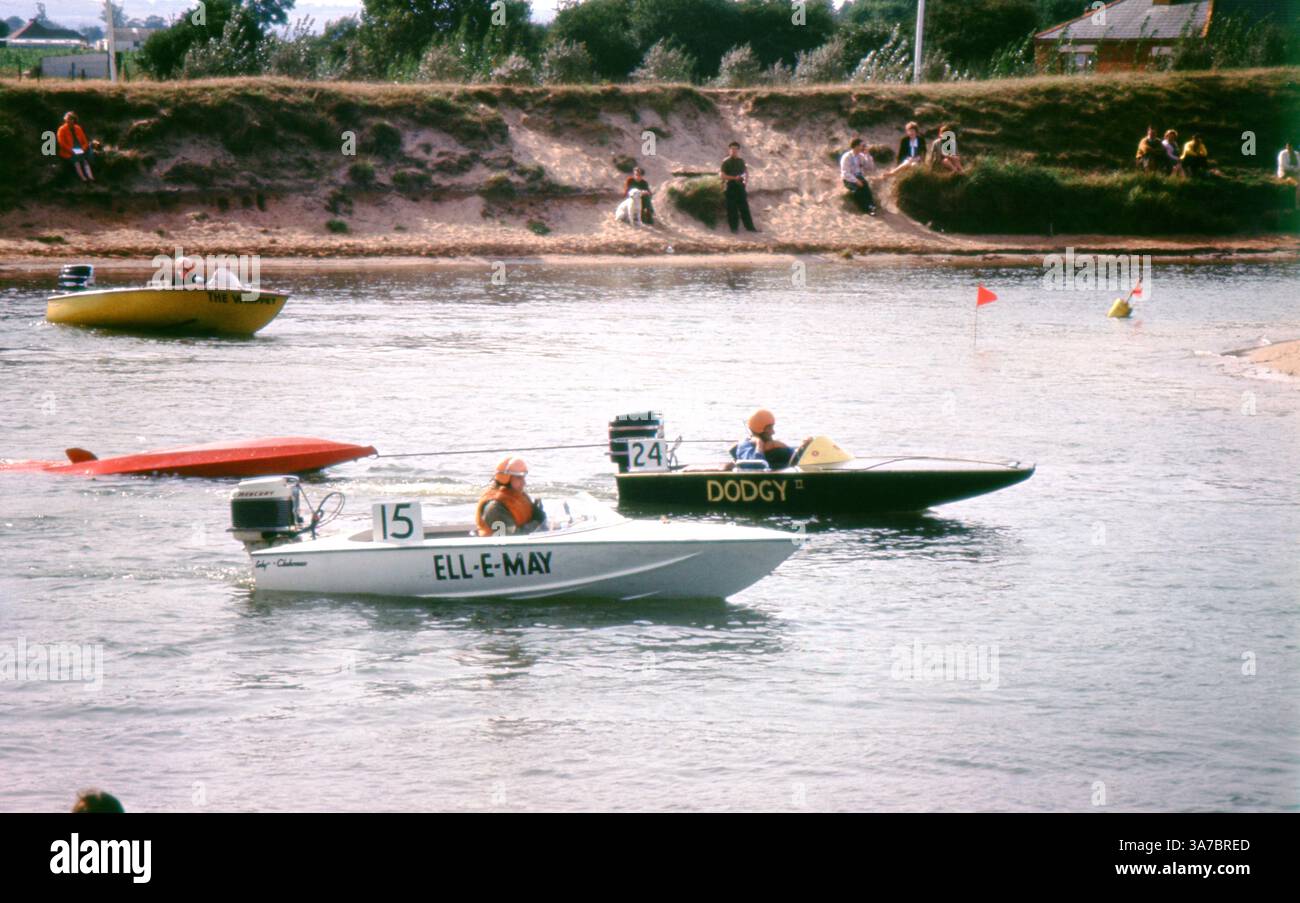 Una scena vivace degli anni '1960 che cattura un'emozionante giornata di corse su motoscafi su un fiume nel Regno Unito, girata su una pellicola slide da 35 mm. Le folle si radunano lungo la riva per allietare i concorrenti mentre le barche dai colori vivaci si allineano e corrono sull'acqua. Foto Stock