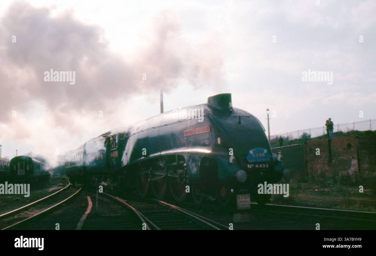 Foto di diapositive originali da 35 mm degli anni '1960 che mostra l'iconica locomotiva a vapore LNER Classe A4 n. 4498 "Sir Nigel Gresley". Catturate durante un evento del patrimonio ferroviario, le immagini mostrano il motore blu aerodinamico circondato da vapore, spettatori e carrozze d'epoca, che evocano l'età d'oro delle ferrovie a vapore britanniche. Foto Stock