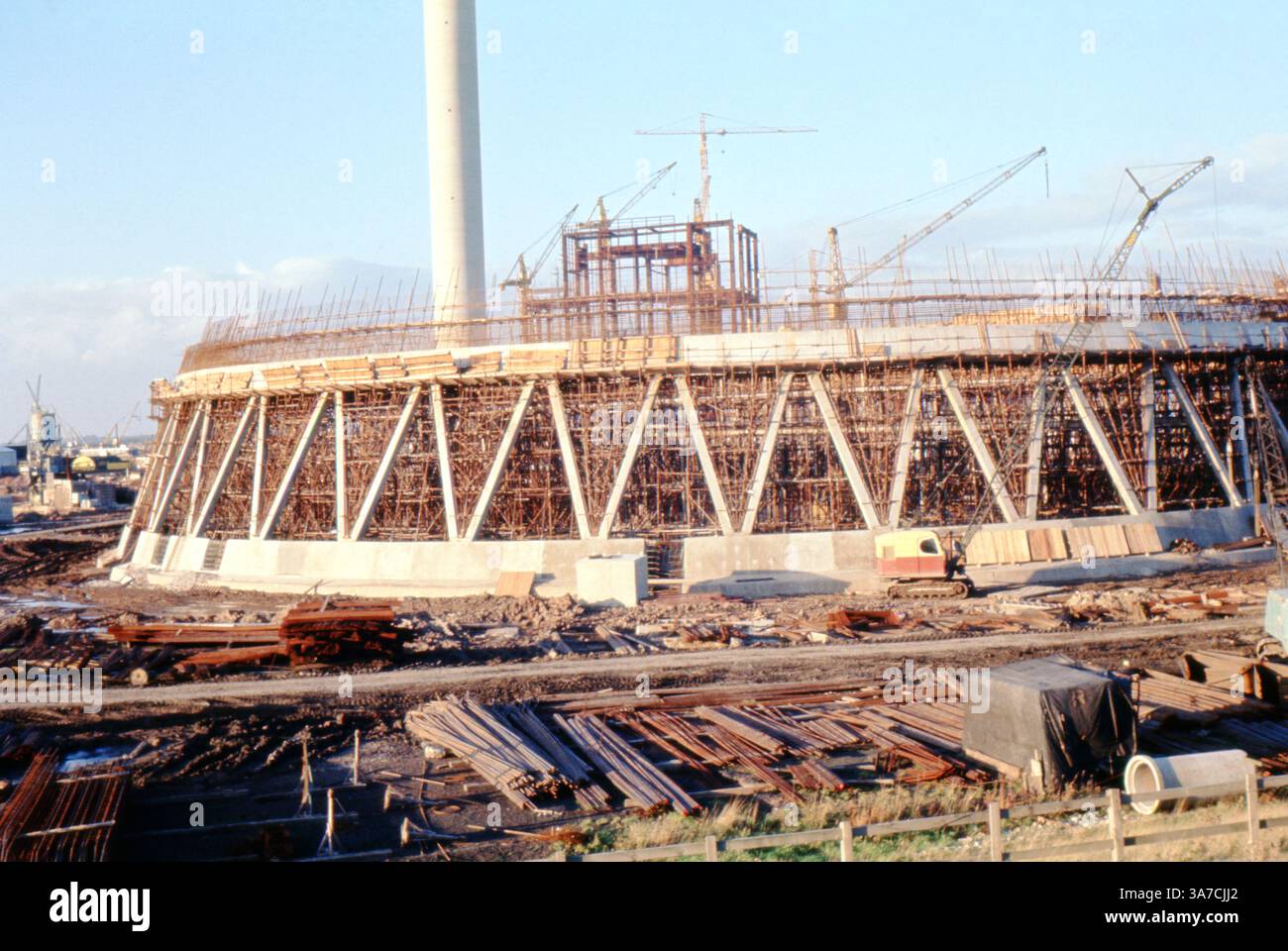 Questa fotografia di aprile 1969 mostra la costruzione della centrale elettrica Ferrybridge C nel West Yorkshire, Inghilterra. L'immagine cattura le prime fasi della struttura di una torre di raffreddamento, con impalcature dense, supporti in calcestruzzo, gru e materiali da costruzione disposti in tutto il sito. Foto Stock