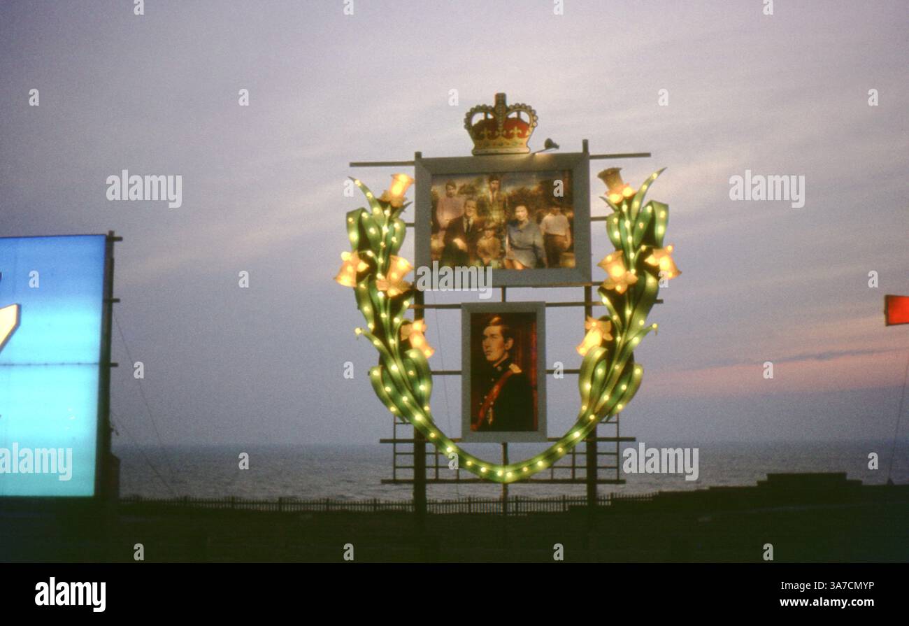 Un tributo illuminato alla famiglia reale britannica, caratterizzato da una corona, gigli luccicanti e ritratti del principe Carlo e della regina, parte delle luci di Blackpool nel 1970 durante un periodo di celebrazione reale. Foto Stock