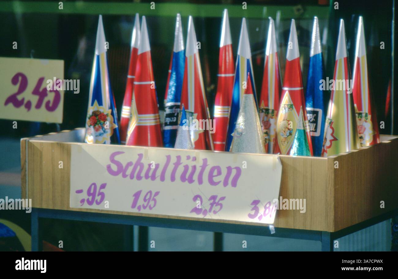 Un'esposizione di coloratissimi Schultüten (coni scolastici) in vendita a Wolfenbüttel, Germania, nel 1972. Questi regali tradizionali a forma di cono, pieni di dolci e piccoli regali, vengono donati ai bambini in Germania il primo giorno di scuola per celebrare il loro inizio nell'istruzione. I prezzi sono scritti a mano in Deutsche Marks. Foto Stock