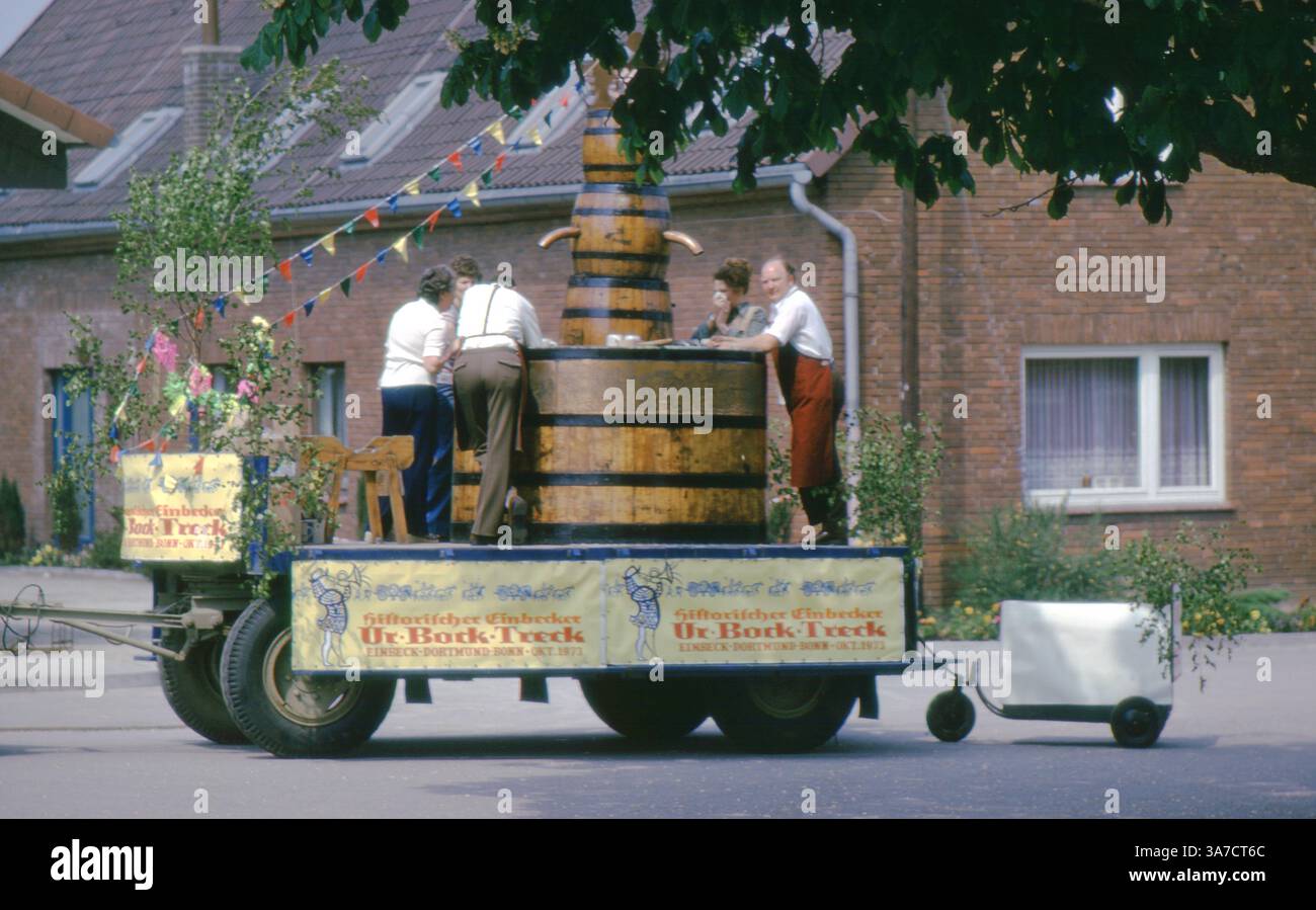Una sfilata decorata galleggiante presso il 1974 Schützenfest di Aligse, Germania, presenta una grande replica di botte di birra in legno sponsorizzata da Einbecker Bier. Etichettato come "Historischer Einbecker Ur-Bock Treck", il galleggiante celebra la storica corsa della birra da Einbeck a Bonn nel 1873, con i partecipanti in costume che servono bevande e cuccioli festivi che esaltano la scena. Foto Stock