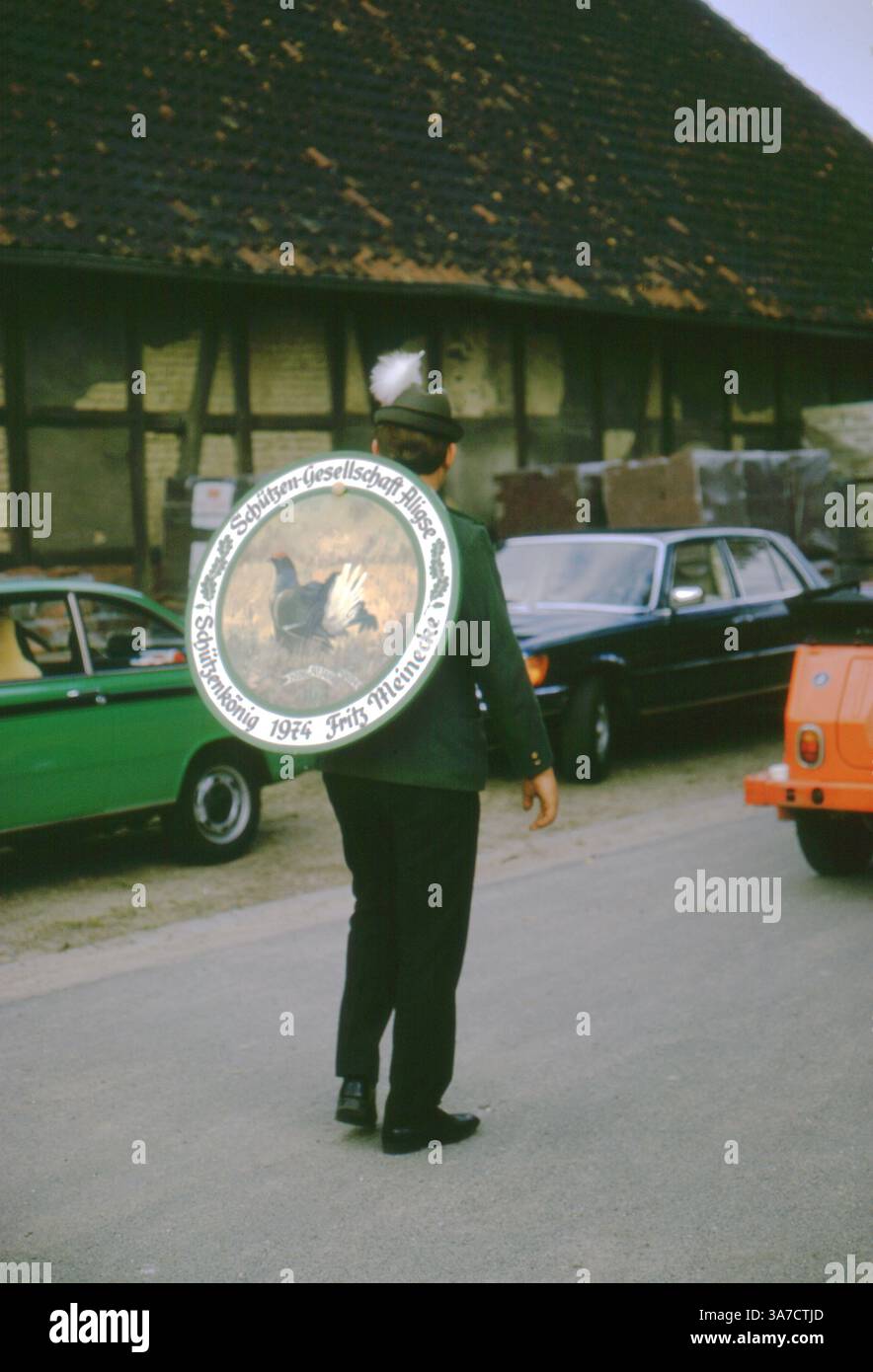 Un partecipante di Schützenfest ad Aligse, in Germania, indossa con orgoglio un bersaglio dipinto cerimoniale che lo contrassegna come il Schützenkönig (re tiratore) del 1974. L'iscrizione nomina Fritz Meinecke come titolare della Schützen-Gesellschaft Aligse. Foto Stock