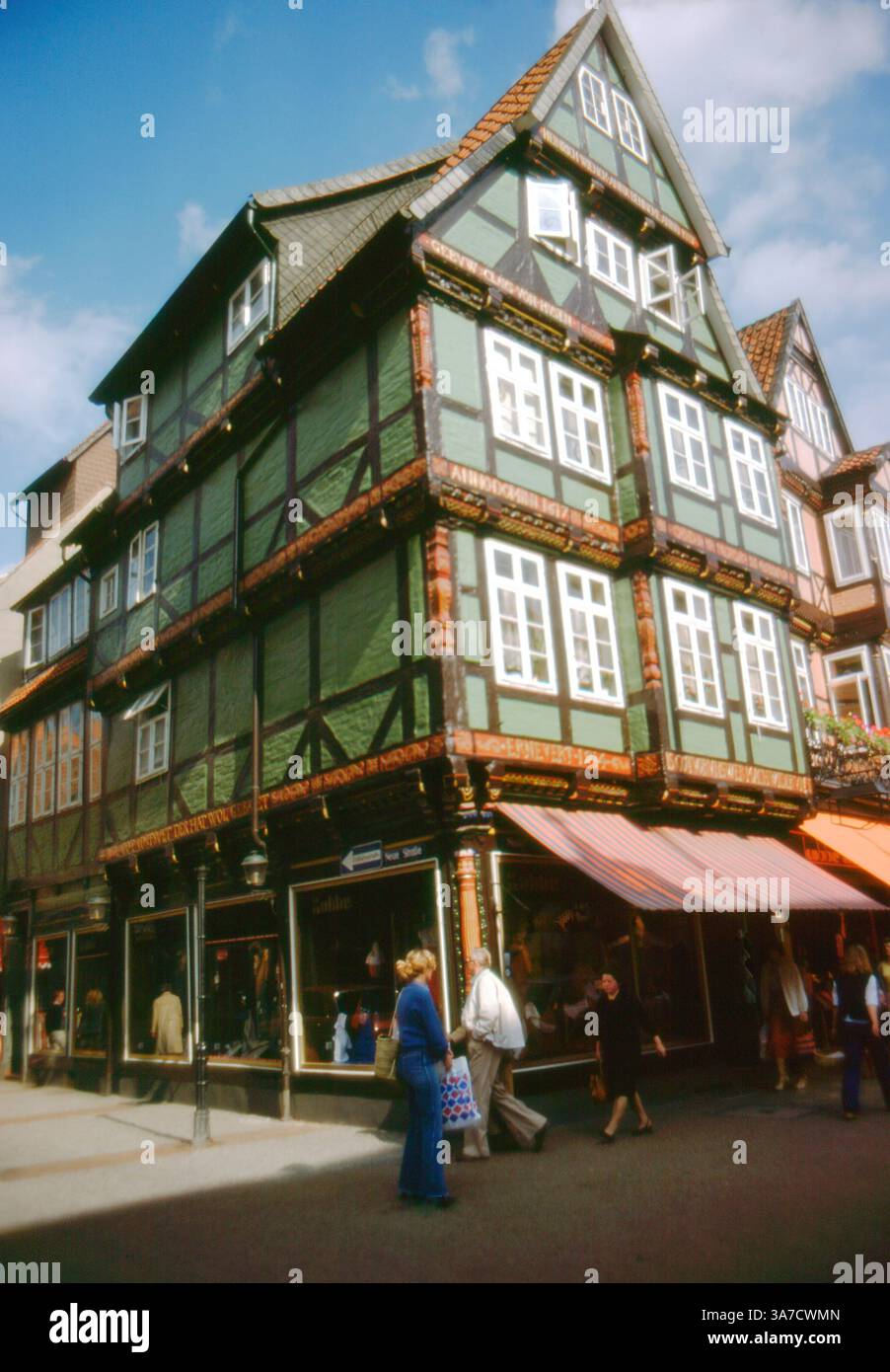 Una vivace scena di strada a celle, bassa Sassonia, Germania, fotografata nel 1979. L'immagine presenta un edificio ben conservato e mezzo in legno tipico della storica Altstadt (città vecchia) della città, decorato con intagli riccamente decorati e iscrizioni dipinte. Foto Stock