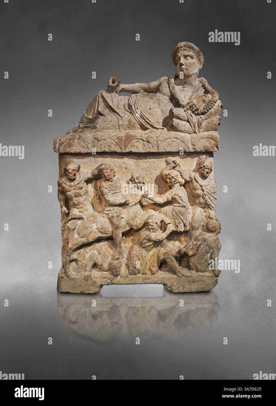 Urna cineraria funeraria etrusca. Il coperchio raffigura un uomo sdraiato su un Kline che regge un Kantharos (calice di vino). I pannelli laterali raffigurano l'omicidio della Foto Stock