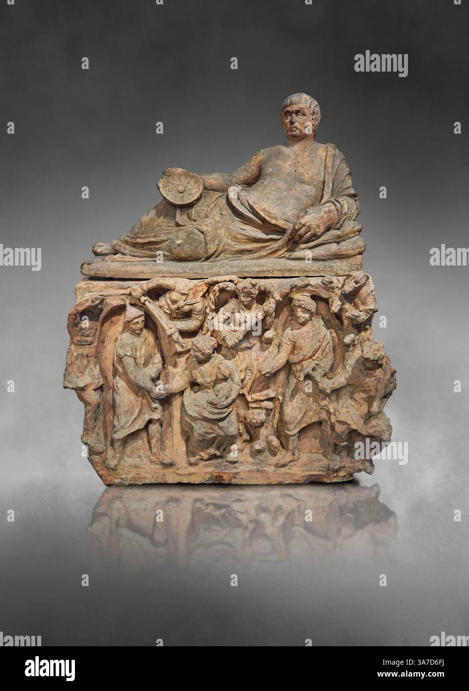 Urna cineraria funeraria etrusca. Il coperchio raffigura un uomo sdraiato su un Kline che regge una ciotola Omphalos. I pannelli laterali raffigurano l'ingresso al sottoscocca Foto Stock