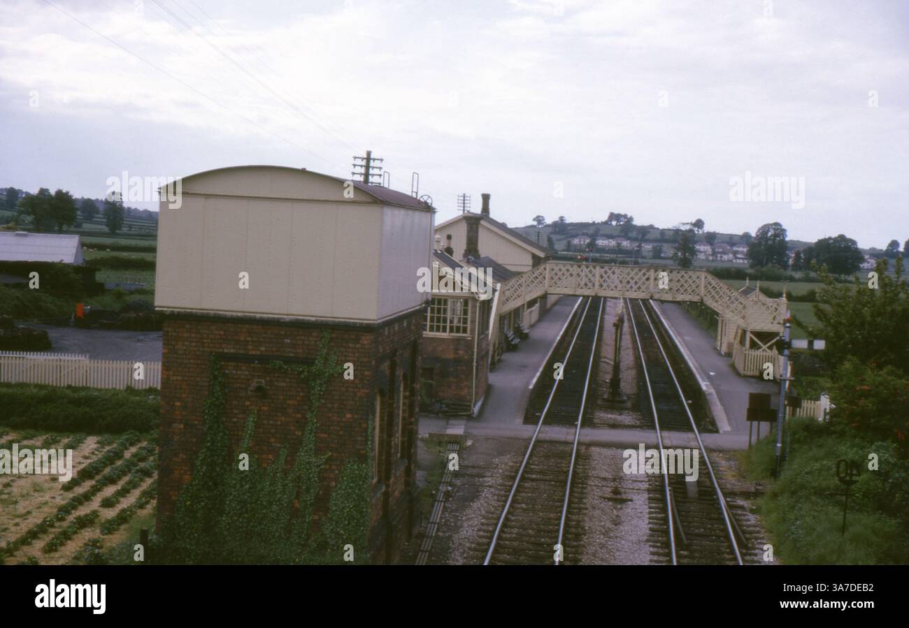Una vista della stazione ferroviaria di Williton nel Somerset, Inghilterra, catturata nei primi anni '1960 Questa stazione rurale si trova sulla West Somerset Railway ed è caratterizzata da un classico ponte pedonale, edifici tradizionali della stazione e un box segnaletico. Foto Stock