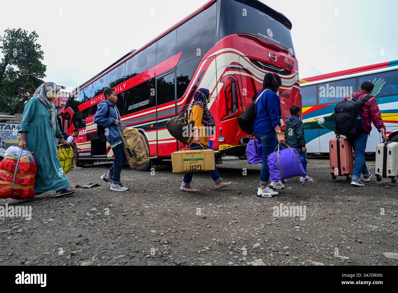 Giacarta, Indonesia. 27 marzo 2025. I passeggeri trasportano i propri effetti personali in una stazione degli autobus prima del festival Eid al-Fitr a Giacarta, Indonesia, 27 marzo 2025. Durante la stagione indonesiana del raduno di Eid, conosciuto come mudik, i residenti di Giacarta lasciano la città dove vivono e lavorano per visitare le loro città natale e celebrare la vacanza con la famiglia allargata. Crediti: Zulkarnain/Xinhua/Alamy Live News Foto Stock