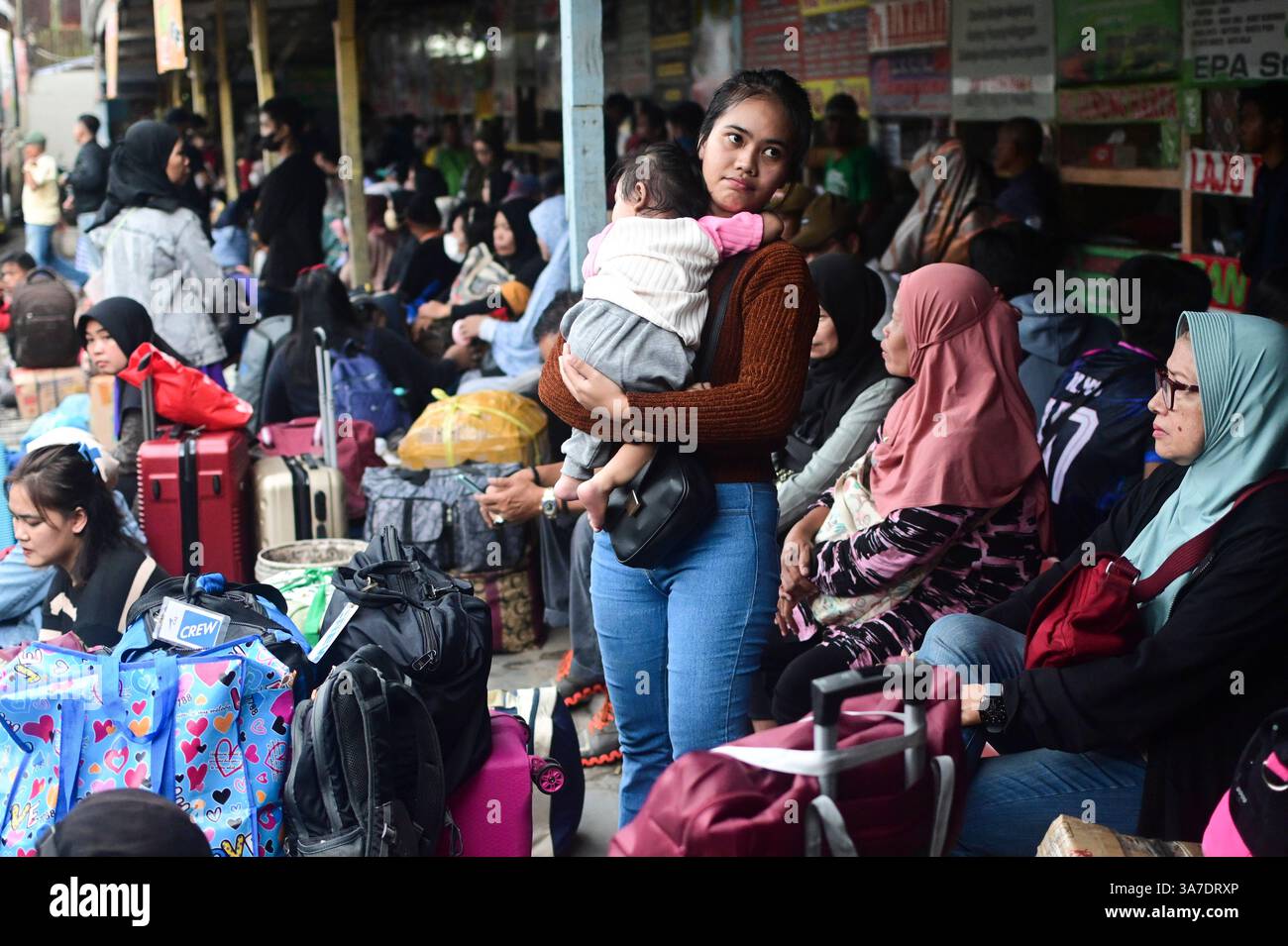 Giacarta, Indonesia. 27 marzo 2025. I passeggeri attendono in una stazione degli autobus prima del festival Eid al-Fitr a Giacarta, Indonesia, 27 marzo 2025. Durante la stagione indonesiana del raduno di Eid, conosciuto come mudik, i residenti di Giacarta lasciano la città dove vivono e lavorano per visitare le loro città natale e celebrare la vacanza con la famiglia allargata. Crediti: Zulkarnain/Xinhua/Alamy Live News Foto Stock