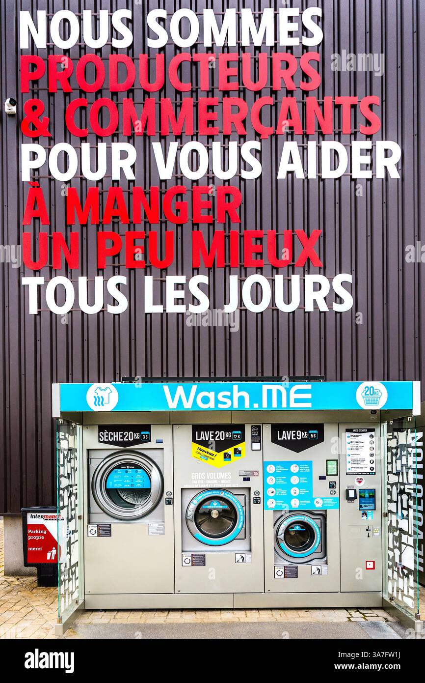 Lavatrici self-service a gettoni Wash.me e asciugatrici vicino all'entrata del negozio InterMarché - Chatellerault, Vienne (86), Francia. Foto Stock