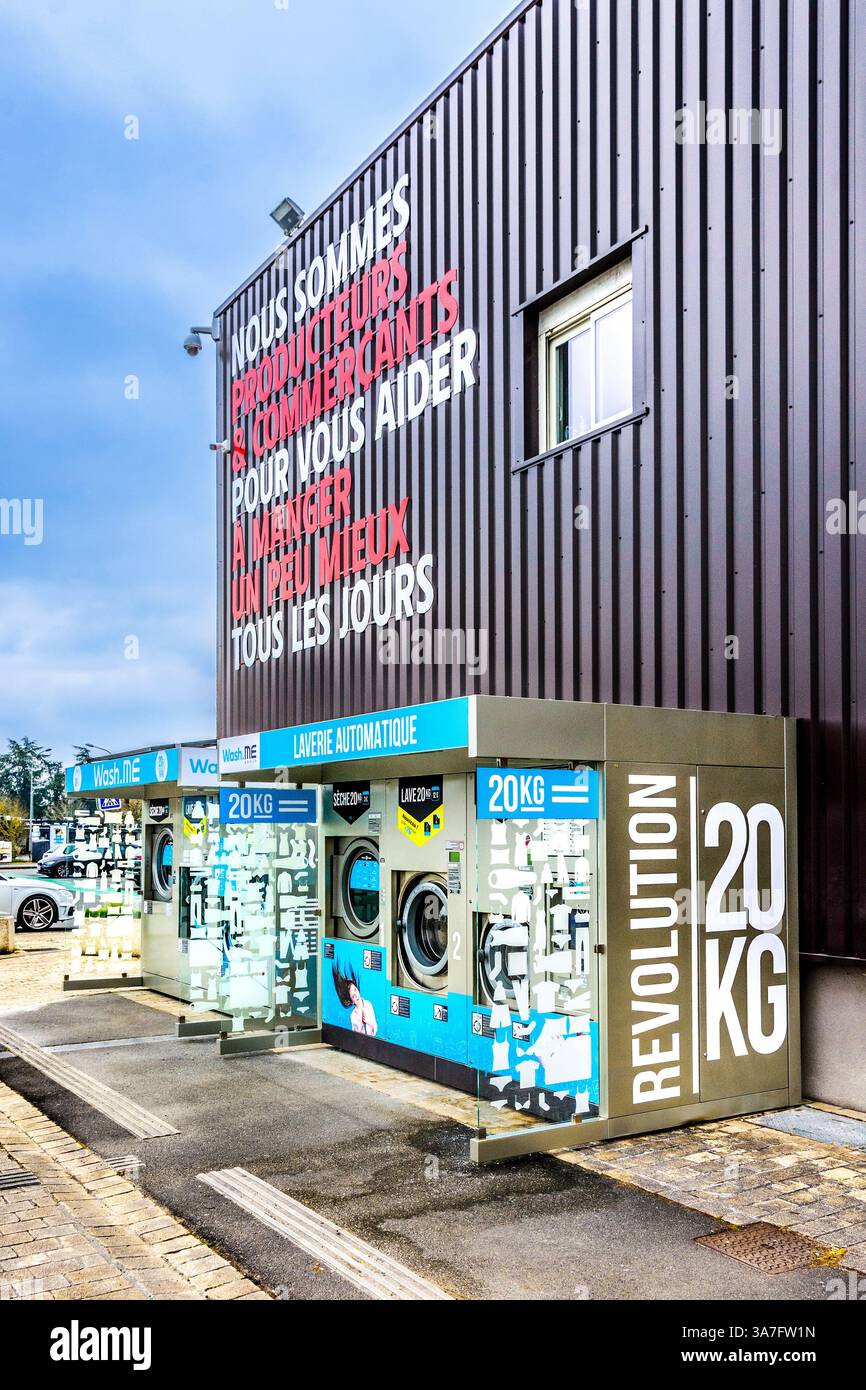 Lavatrici self-service a gettoni Wash.me e asciugatrici vicino all'entrata del negozio InterMarché - Chatellerault, Vienne (86), Francia. Foto Stock