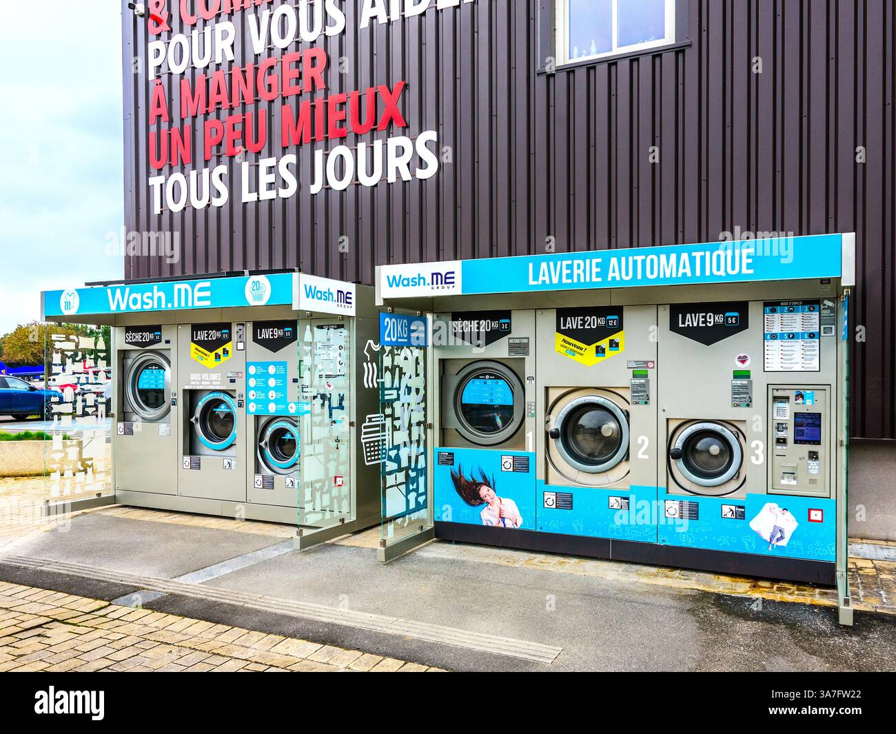 Lavatrici self-service a gettoni Wash.me e asciugatrici vicino all'entrata del negozio InterMarché - Chatellerault, Vienne (86), Francia. Foto Stock