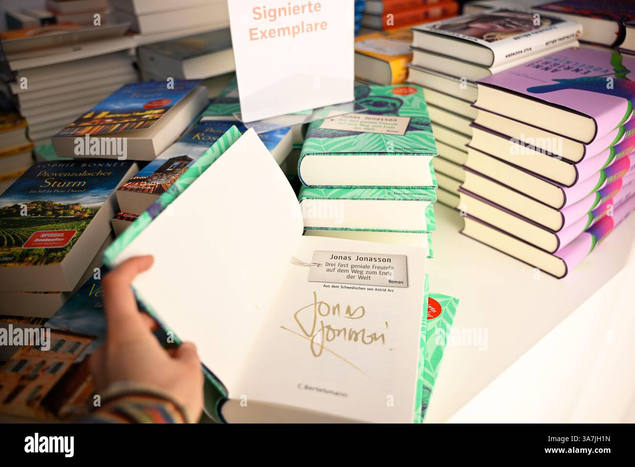 Lipsia, Germania. 27 marzo 2025. Una donna sfoglia un libro firmato alla Fiera del Libro di Lipsia. Fino al 30.03.2025, 2.040 espositori provenienti da 45 paesi presenteranno nuovi prodotti in questa primavera del libro. Il motto della fiera di quest'anno è "le parole muovono i mondi”. Il paese ospite di quest'anno è la Norvegia. Credito: ELISA Schu/dpa/Alamy Live News Foto Stock