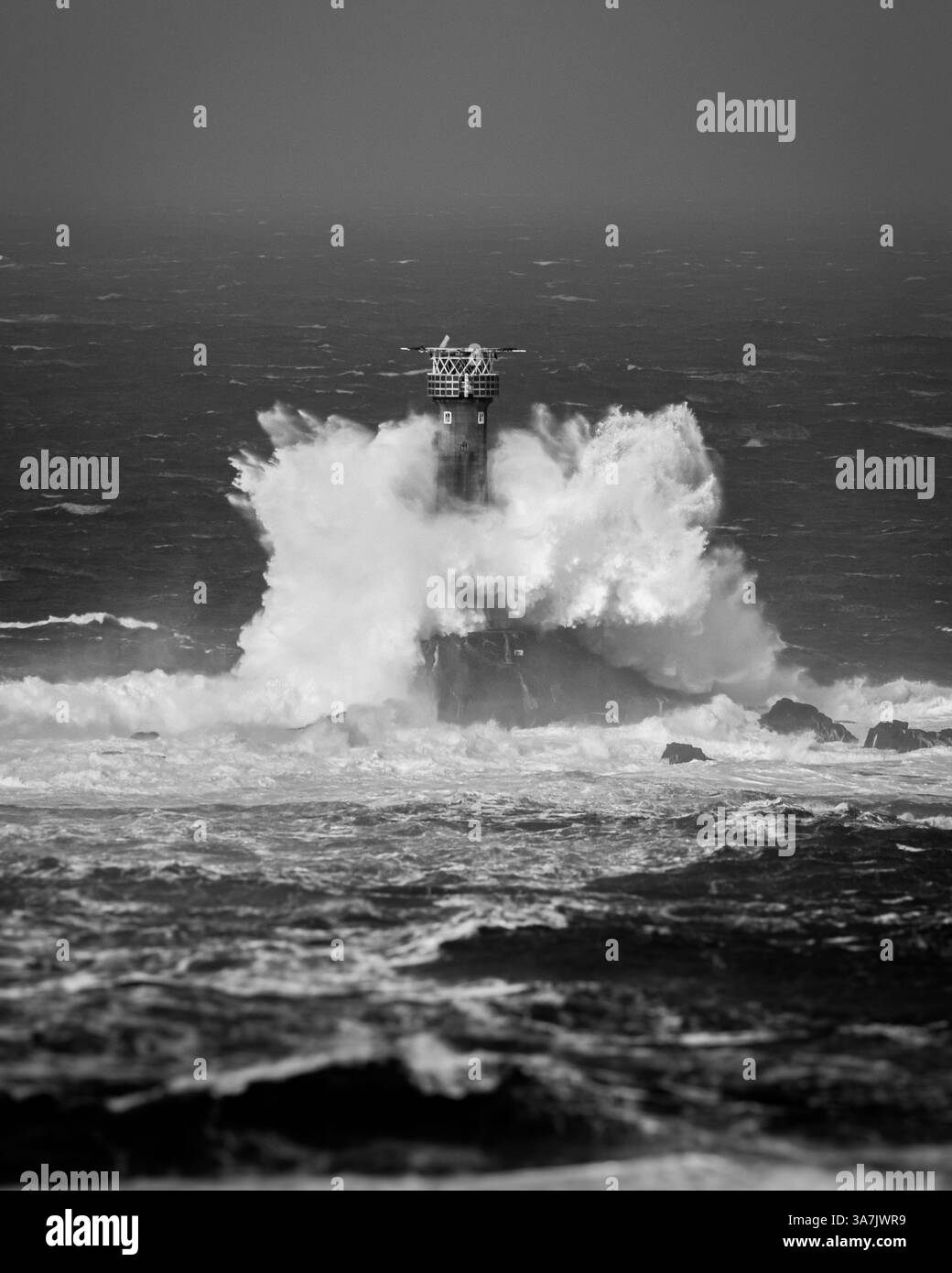 Grandi onde che si infrangono sul faro di Longships e terminano la Cornovaglia in mari molto pesanti durante una tempesta che colpisce la costa della Cornovaglia Foto Stock
