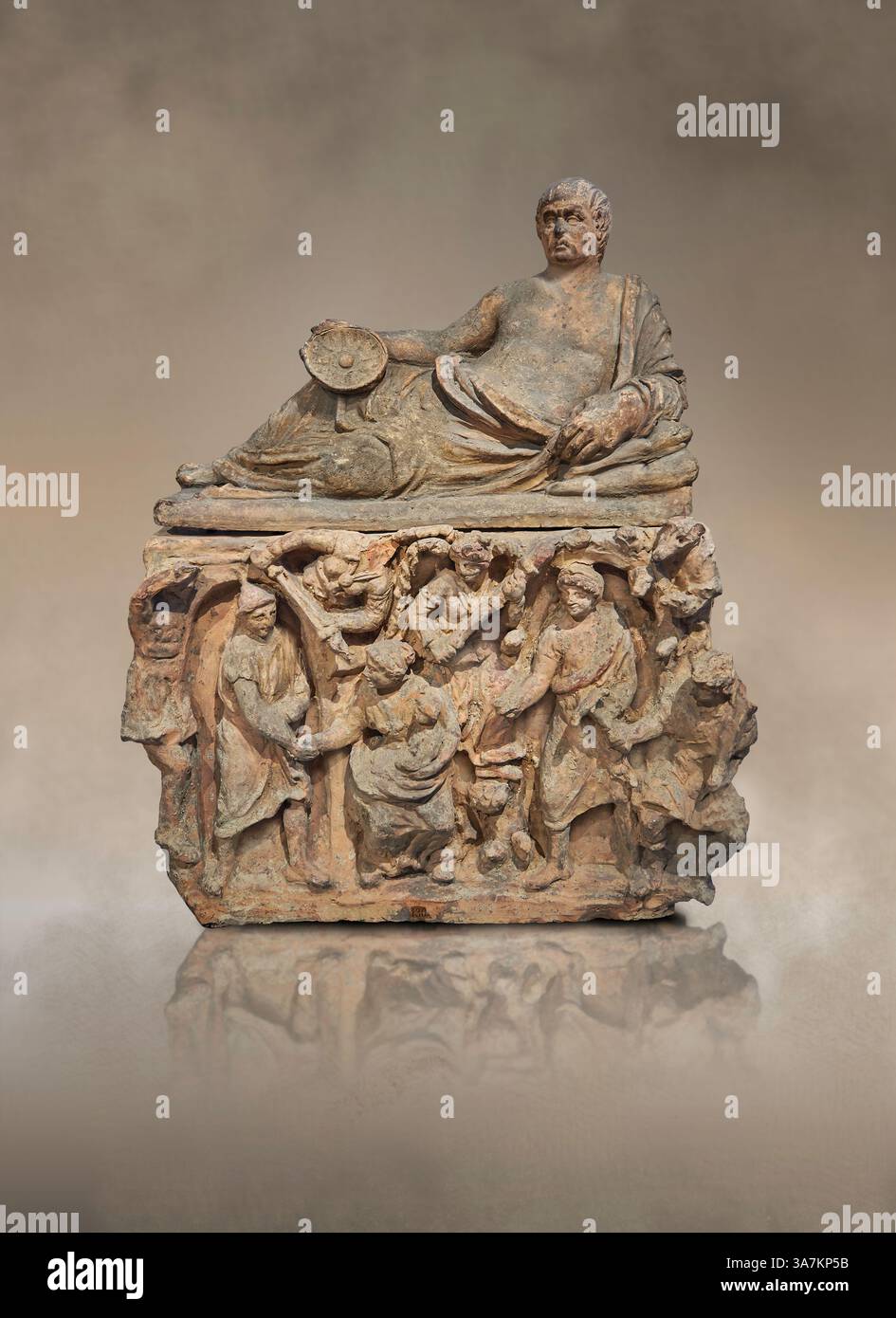 Urna cineraria funeraria etrusca. Il coperchio raffigura un uomo sdraiato su un Kline che regge una ciotola Omphalos. I pannelli laterali raffigurano l'ingresso al sottoscocca Foto Stock