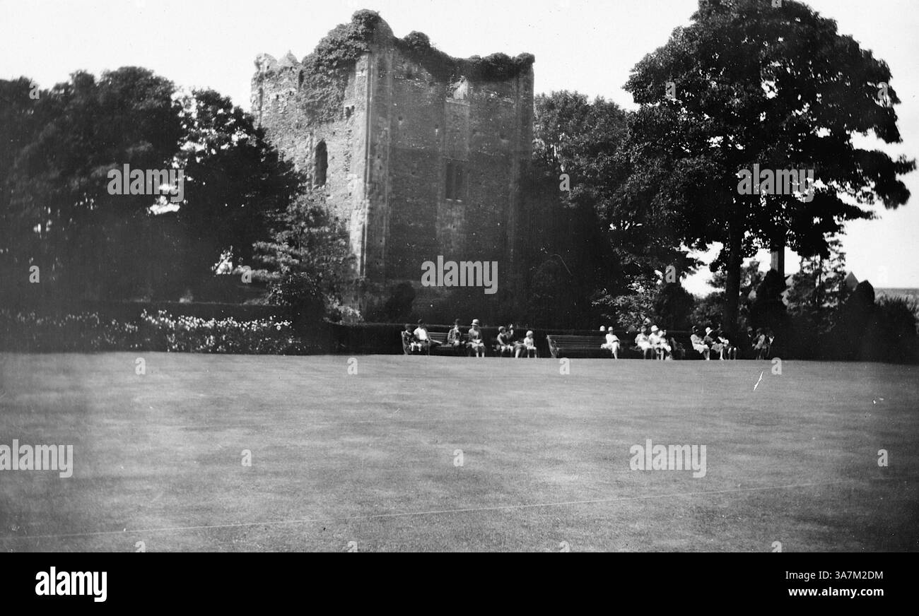 1929, una vista del castello di Guildford nel Surrey, Inghilterra. Si ritiene che sia stato costruito poco dopo la conquista normanna del 1066, probabilmente da Guglielmo il Conquistatore o da uno dei suoi baroni. Il castello presenta un design motte-and-bailey, con un mastio costruito in pietra di Bargate. In questa foto le persone sono viste nei giardini su panchine accanto alla torre. Da una raccolta di fotografie amatoriali non attribuite nell'intervallo di date, 1929-1936, che includono le festività del Regno Unito e dell'Europa. La maggior parte delle immagini originali erano circa 3 ½ x 2 pollici. Foto Stock