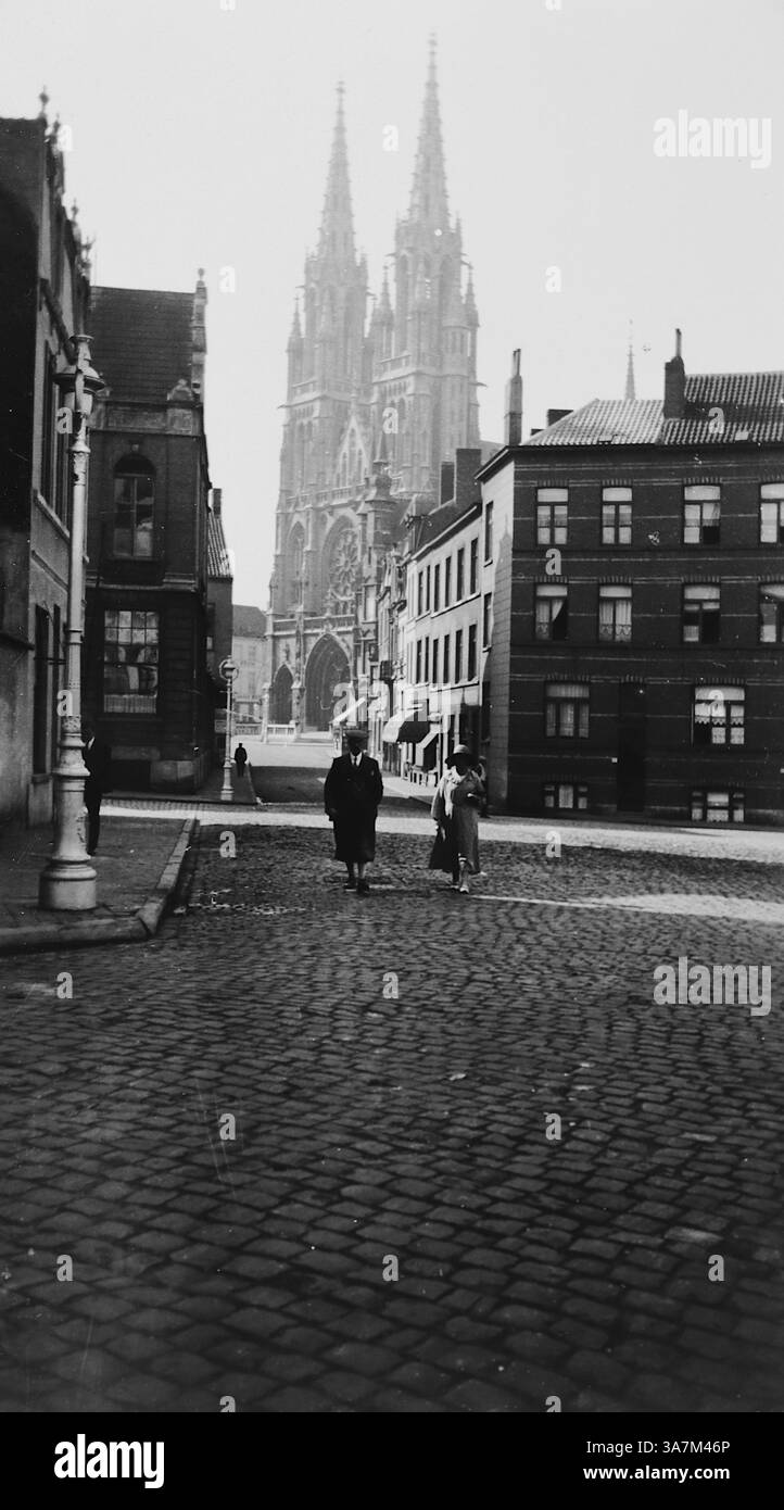 1932, una vista sulla strada con le torri gemelle della Cattedrale di Ostenda sullo sfondo. La chiesa di San Pietro e San Paolo (Sint-Petrus-en-Pauluskerk) è una chiesa neogotica di Ostenda, Belgio. Fu costruito tra il 1899 e il 1908. Da una raccolta di fotografie amatoriali non attribuite nell'intervallo di date, 1929-1936, che includono le festività del Regno Unito e dell'Europa. La maggior parte delle immagini originali erano circa 3 ½ x 2 pollici. Foto Stock