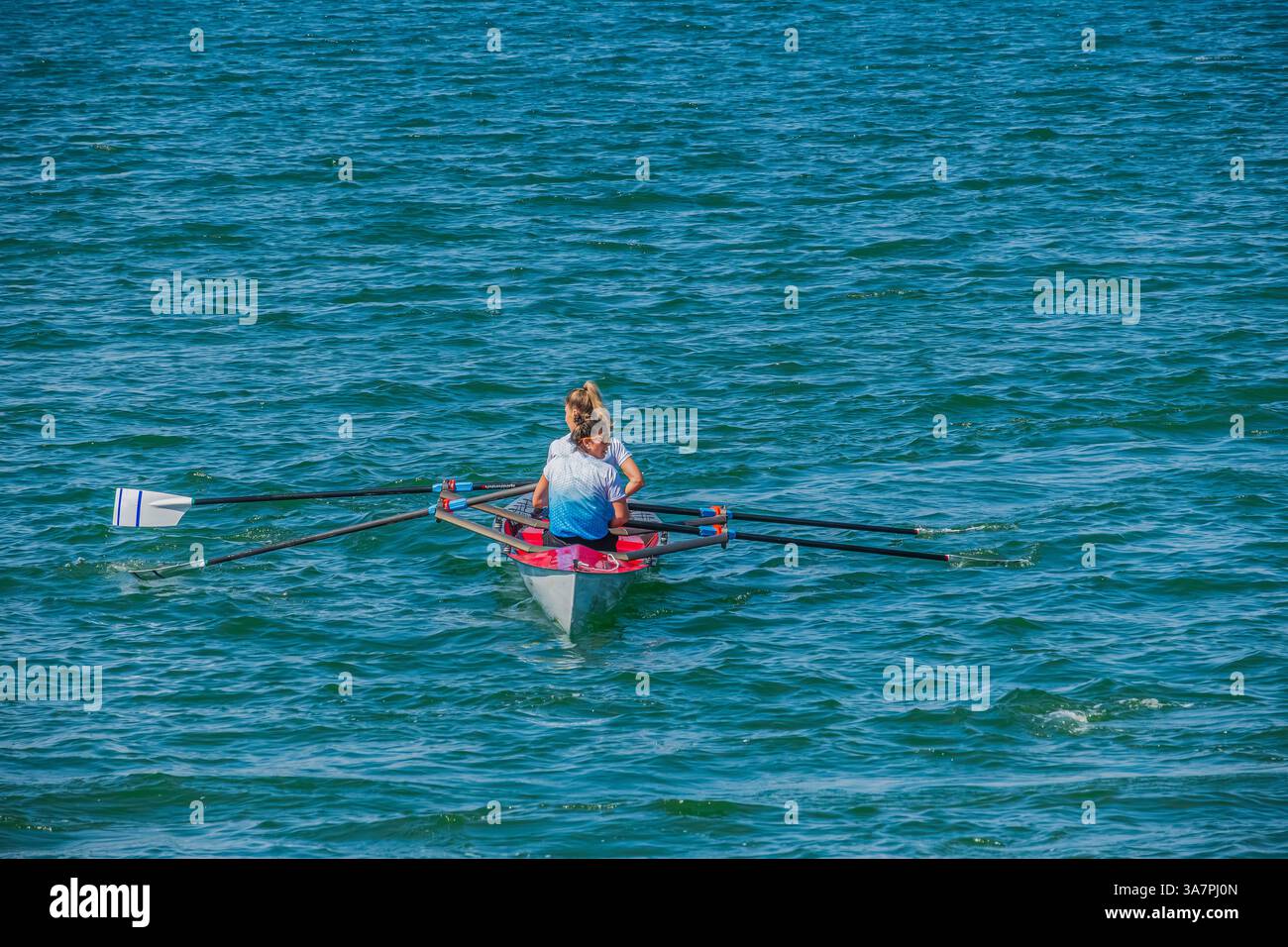 Canottaggio a singolo scasso sulle acque di Fethiye: Una fila singola una singola barca a scasso sulle acque moderatamente instabili e soleggiate Foto Stock