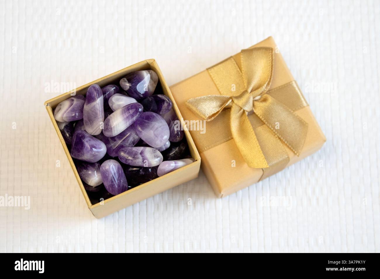 set di varie pietre minerali naturali ametista e pietre preziose su sfondo viola, vista dall'alto parzialmente messa a fuoco Foto Stock