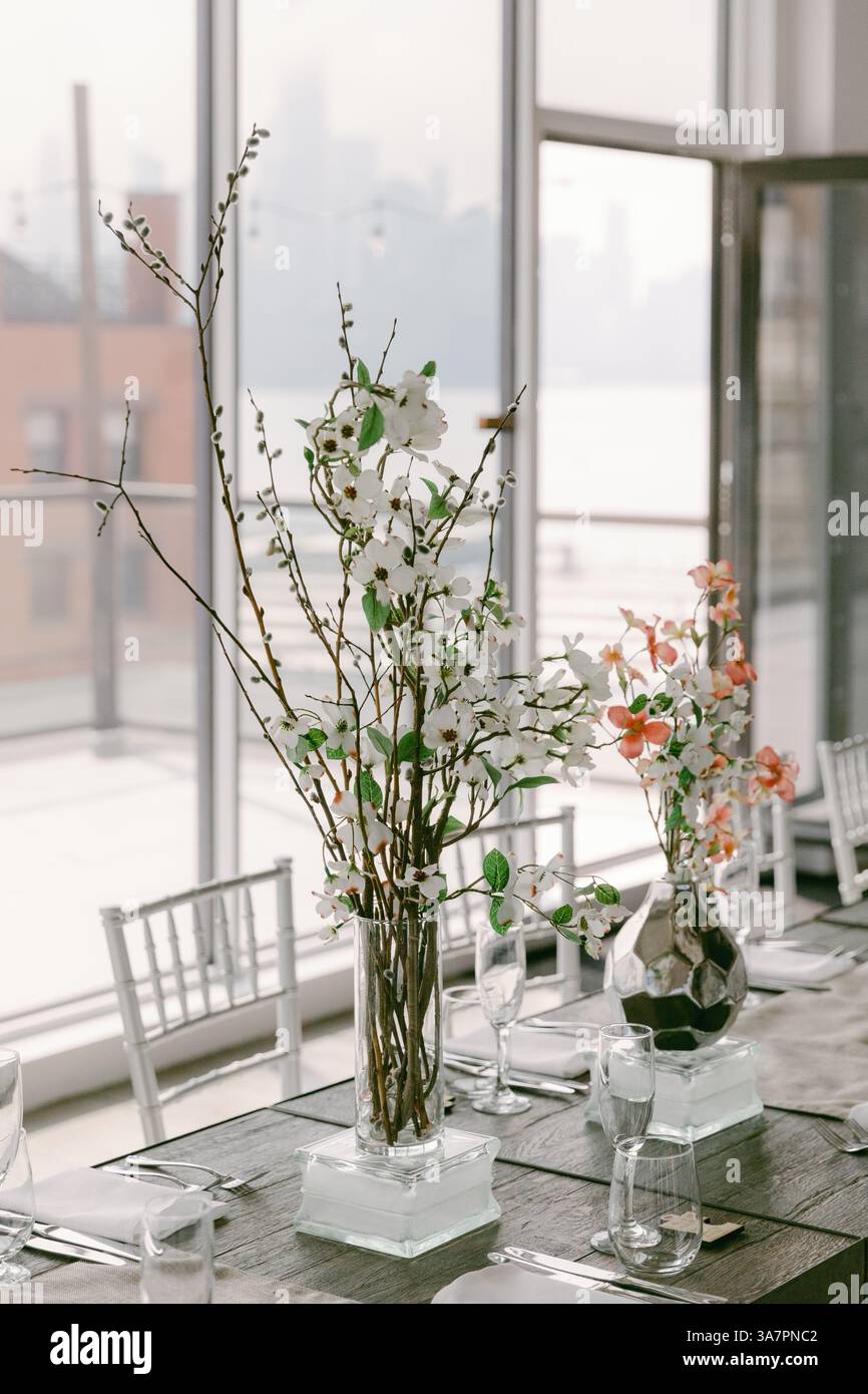 I fiori primaverili in eleganti vasi arricchiscono l'ambiente elegante con vista sulla città, perfetto per riunioni e celebrazioni. Foto Stock