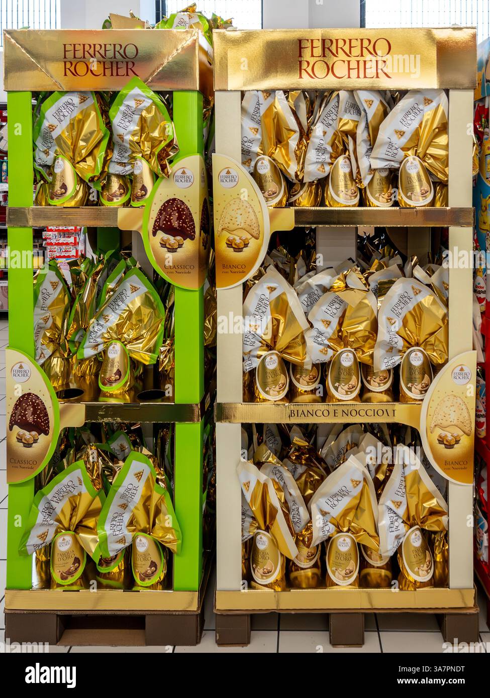 Italia - 25 marzo 2025: Uova di cioccolato pasquale Ferrero Rocher con cioccolatini rocker a sorpresa in esposizione in cartone dorato in vendita in supermar italiano Foto Stock
