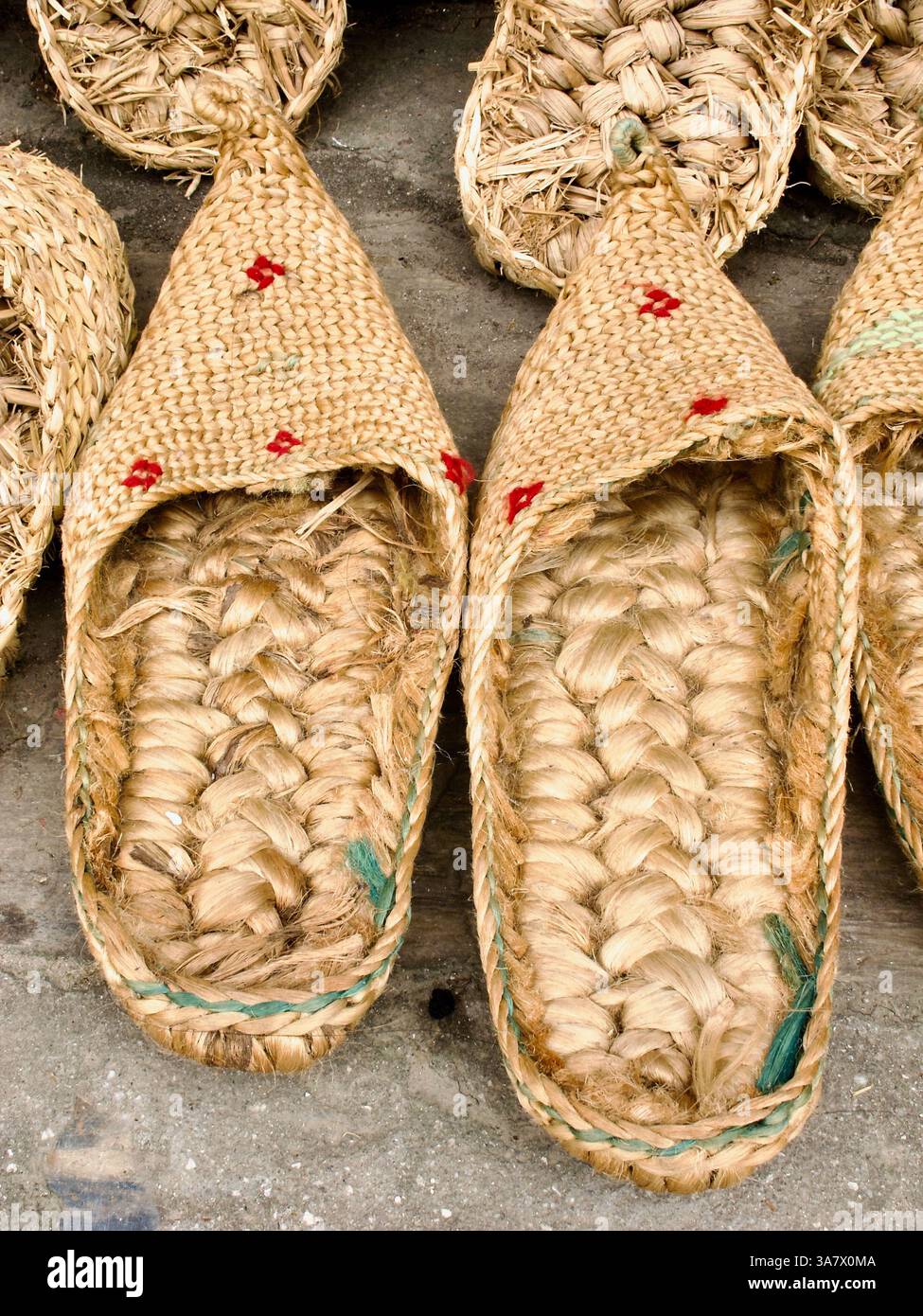 Tradizionali scarpe docha fatte a mano tessute in paglia, esposte in un mercato di strada a Kathmandu, Nepal. Foto Stock