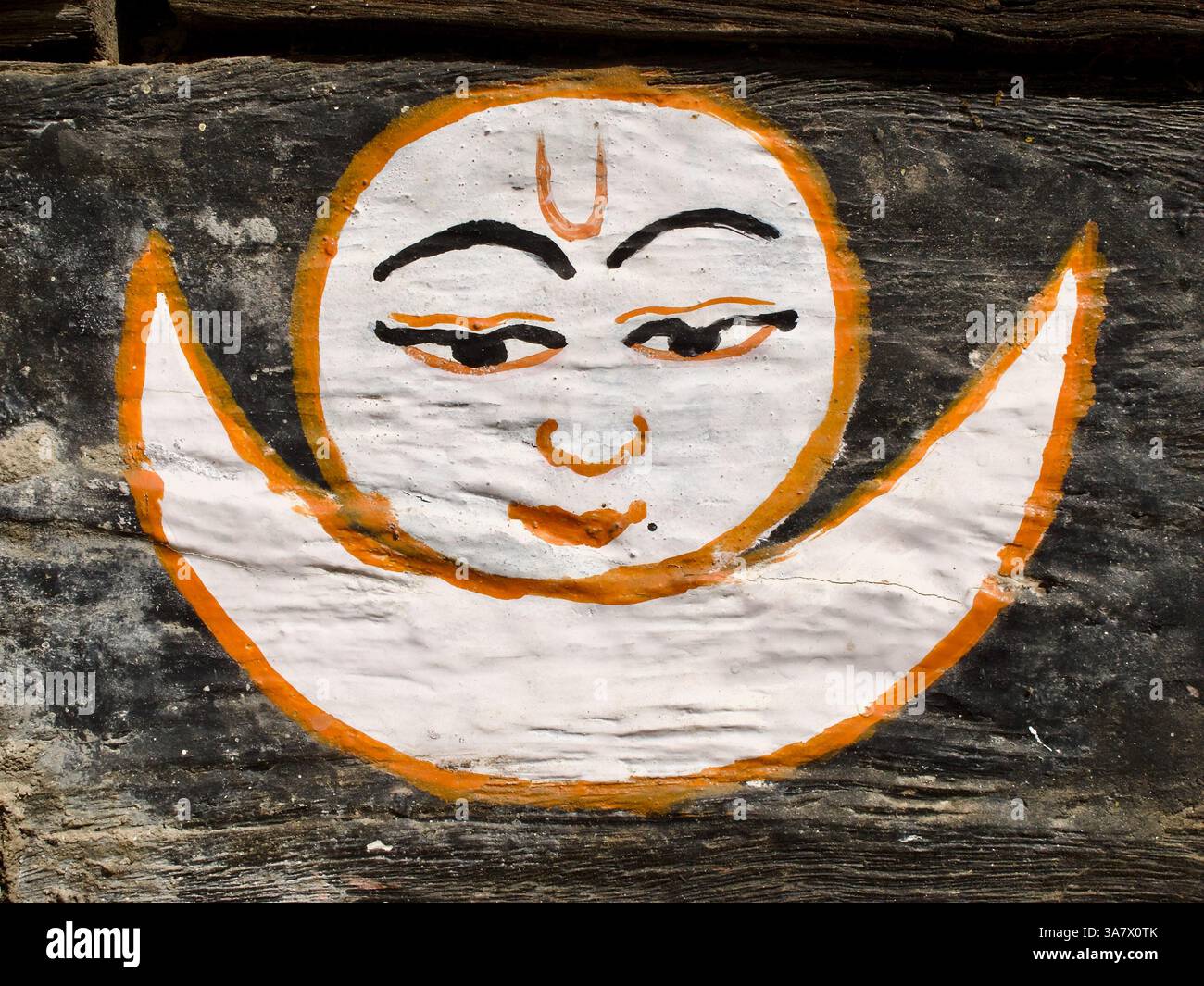 Pittura del volto della Luna su legno in un tempio Newar a Patan, Nepal, che rappresenta la notte, l'equilibrio e la protezione nell'iconografia buddista locale. Foto Stock