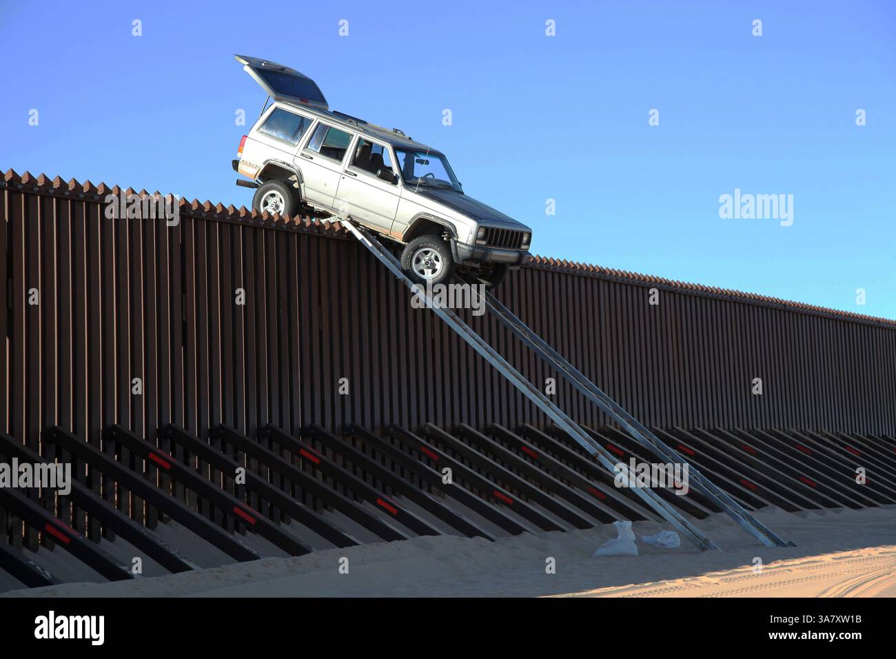 31 ottobre 2012 - Yuma, Arizona, Stati Uniti - due aspiranti contrabbandieri sono stati sventati nel tentativo di attraversare il confine messicano in Arizona su una rampa di passaggio quando la loro Jeep è rimasta bloccata in cima alla recinzione di 14 piedi, secondo gli agenti di frontiera della pattuglia di frontiera degli Stati Uniti che pattugliavano il settore Yuma intorno a mezzanotte martedì è arrivata la Jeep Cherokee d'argento che aveva raggiunto un "alto centro" mentre cercava di attraversare la parte inferiore della rampa. Due sospettati sono fuggiti in Messico. (Immagine di credito: © USCBP/ZUMAPRESS.com) Foto Stock