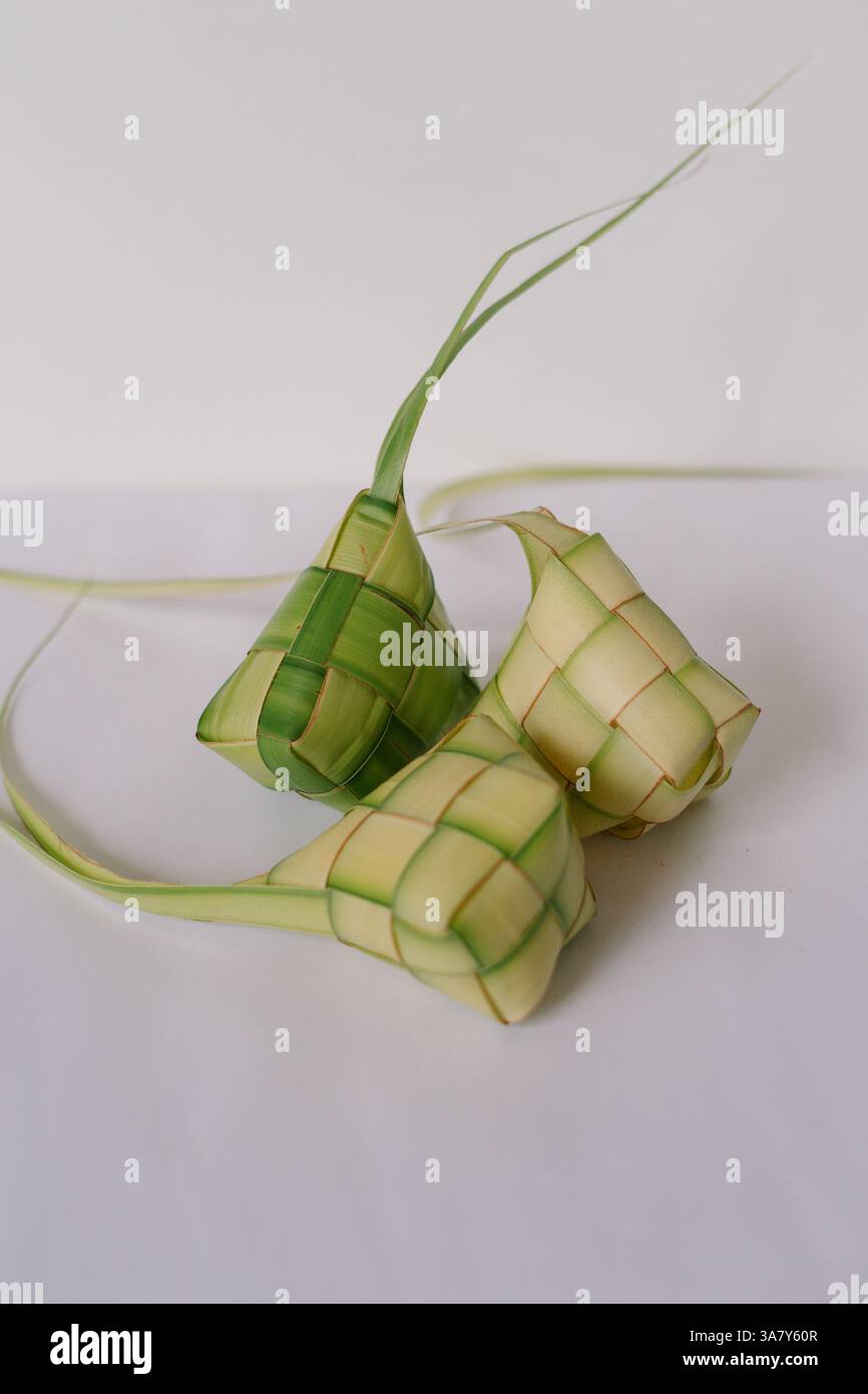 Primo piano di ketupat, gnocchi di riso tradizionali, serviti durante la celebrazione di Eid al-Fitr. Questi gnocchi sono avvolti in foglie di cocco intrecciate e lo sono Foto Stock