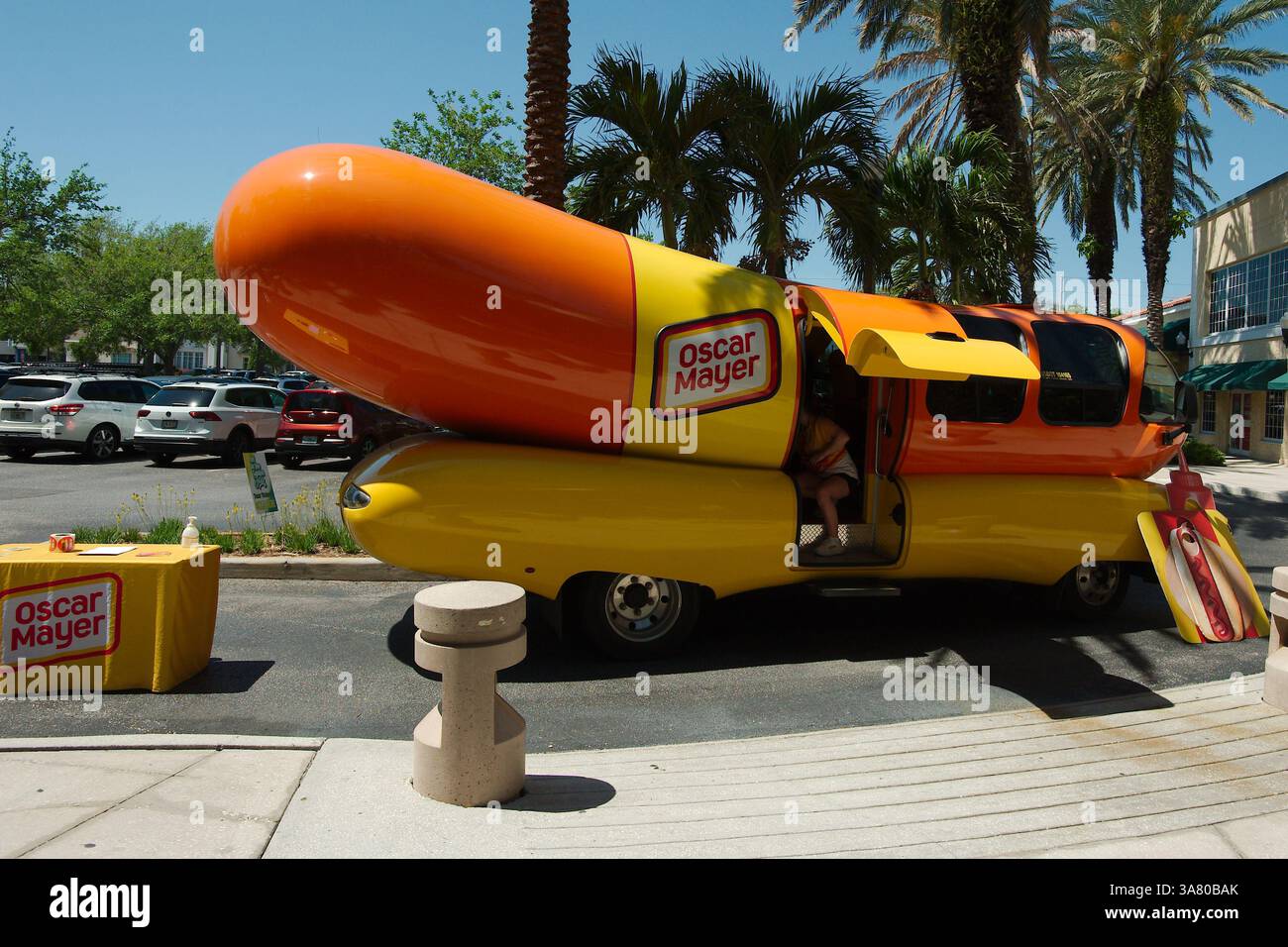 Uso editoriale solo 27 marzo 2025 St. Petersburg, FL, USA. Oscar Mayer Wienermobile veicolo promozionale a forma di hot dog su un panino. Orange e yel Foto Stock