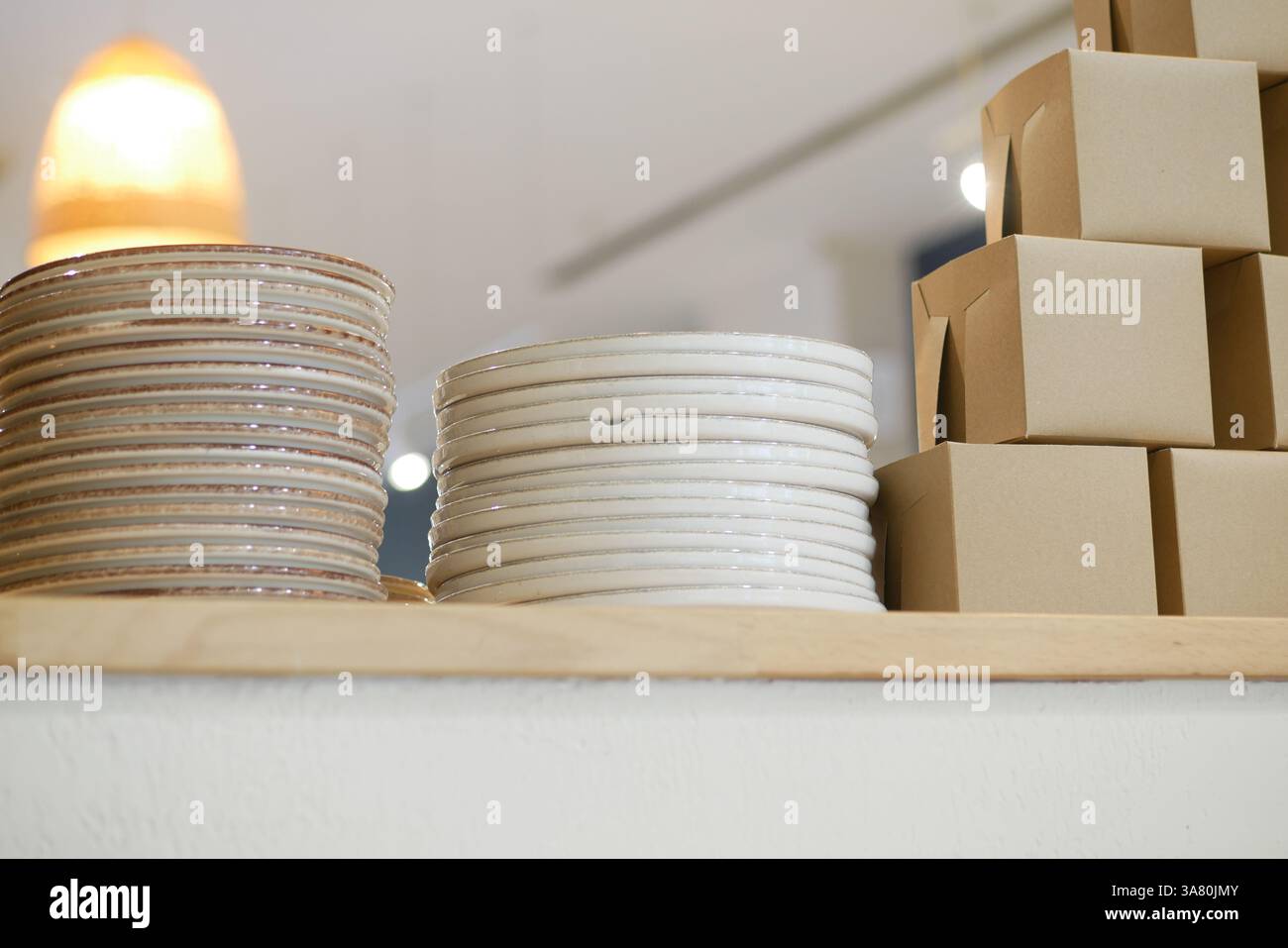 Piatti impilati e cassette da asporto in un moderno ambiente da caffe' Foto Stock