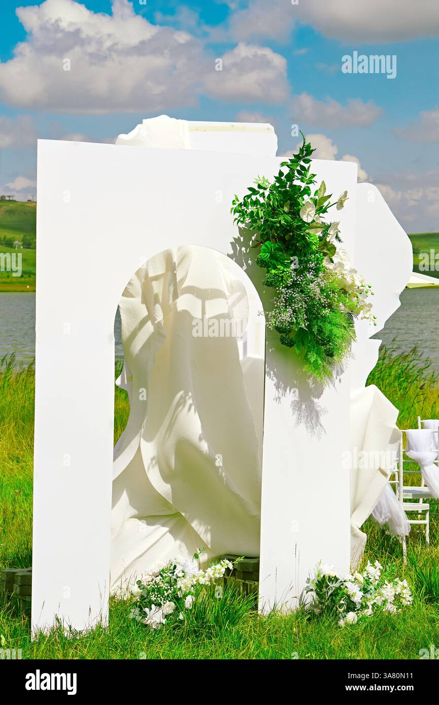 Sala per matrimoni fronte lago con tenda bianca e decorazioni floreali Foto Stock