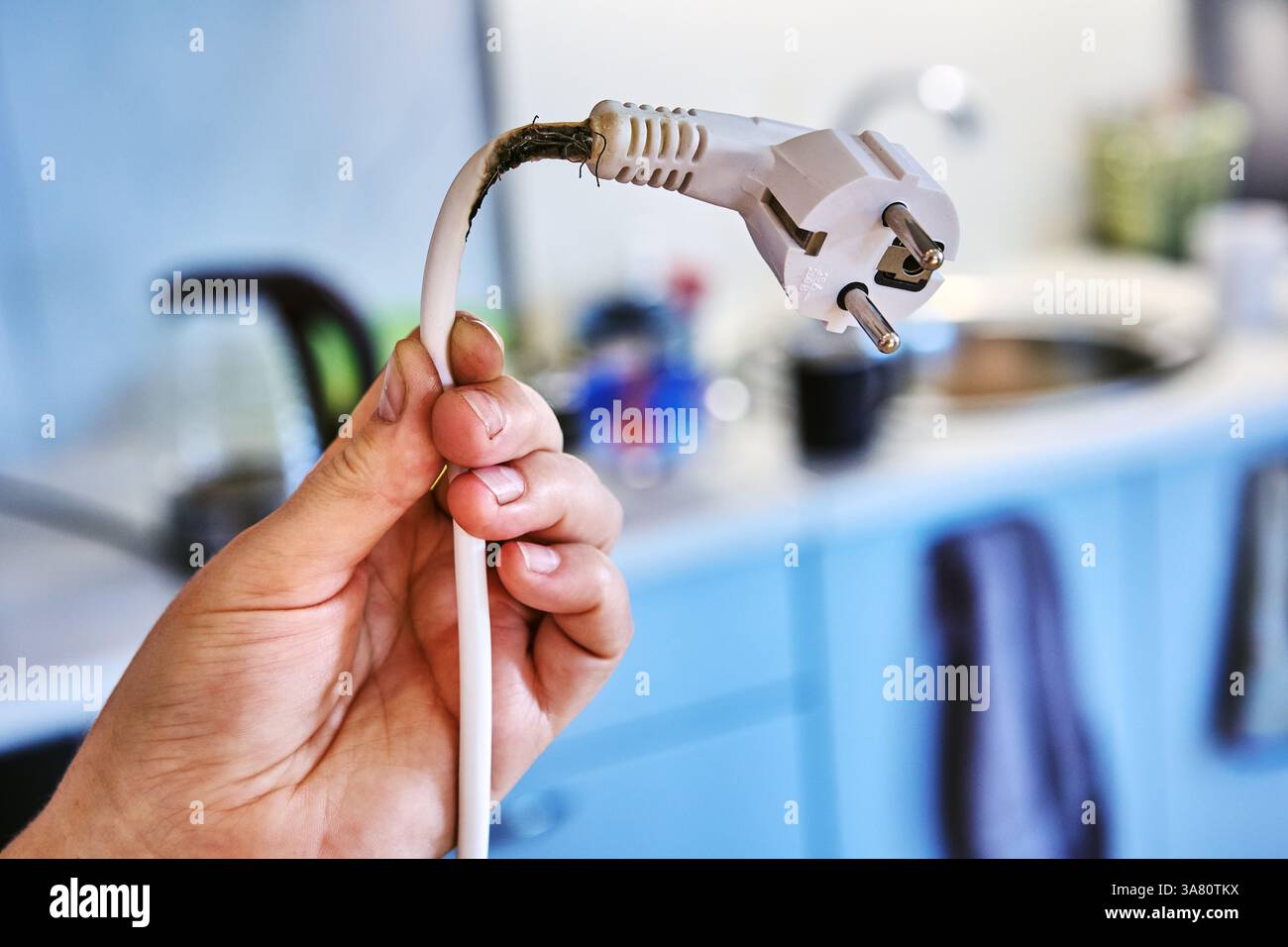 Un contatto inadeguato tra presa e spina ha causato il bruciamento del cavo di alimentazione e ha quasi causato un incendio. Foto Stock