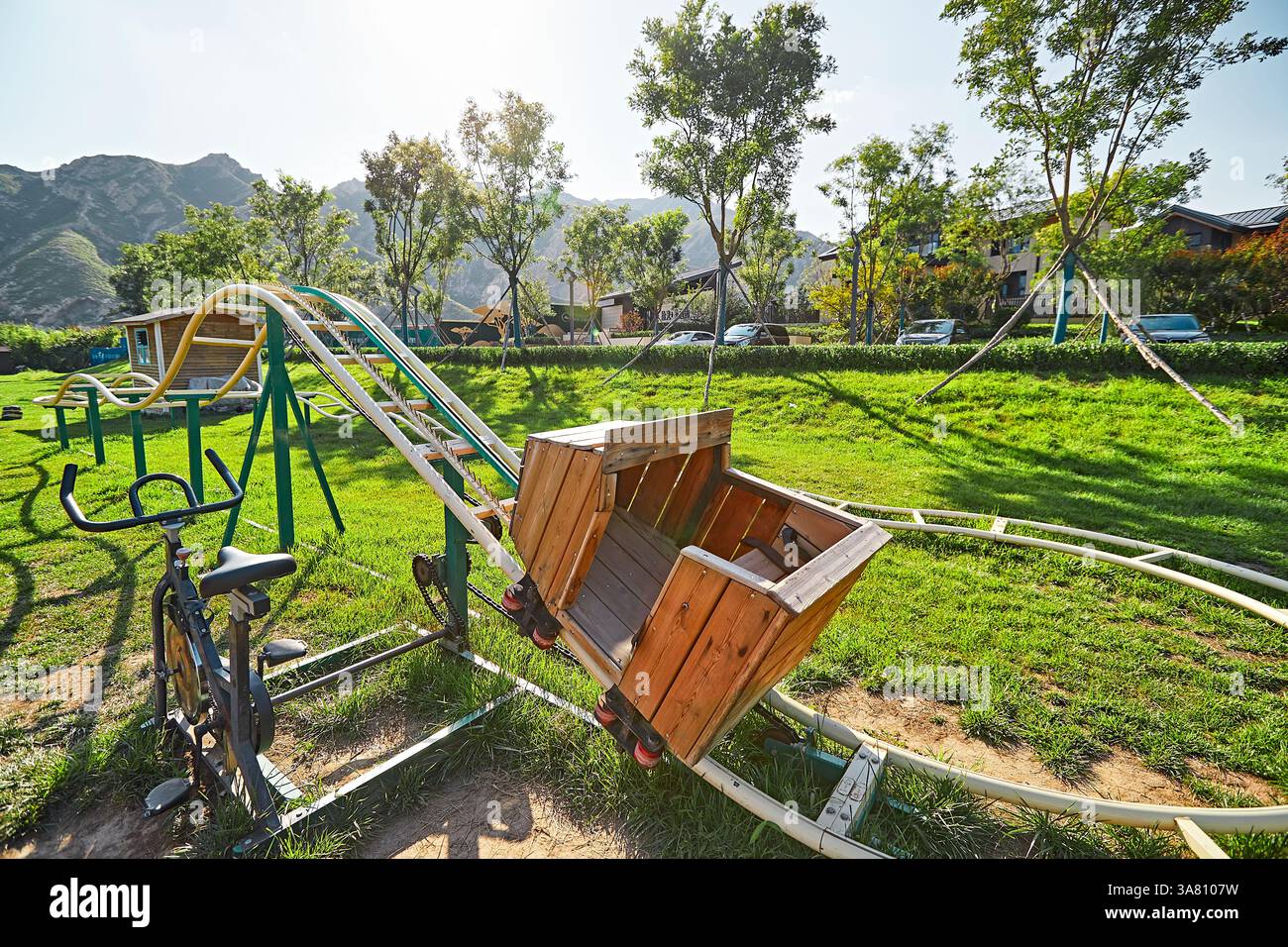 Parco per famiglie con attrezzature da gioco e vegetazione Foto Stock