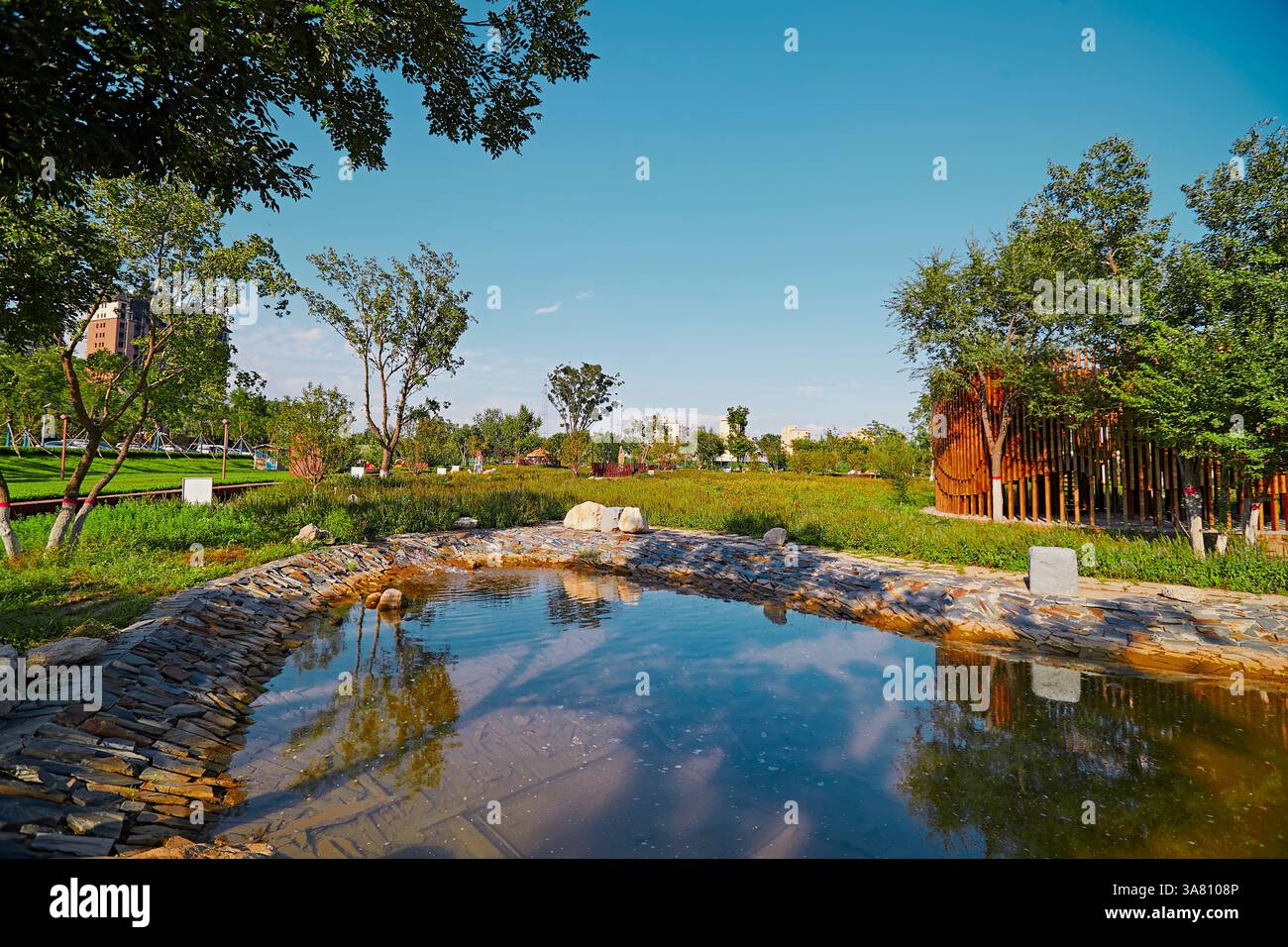 Parco per famiglie con attrezzature da gioco e vegetazione Foto Stock