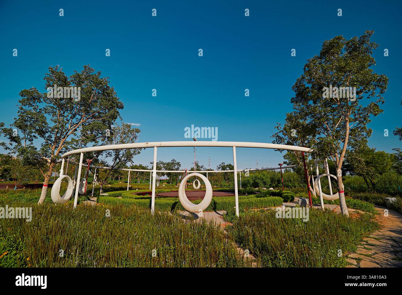 Parco per famiglie con attrezzature da gioco e vegetazione Foto Stock