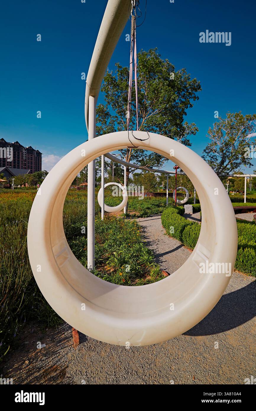 Parco per famiglie con attrezzature da gioco e vegetazione Foto Stock