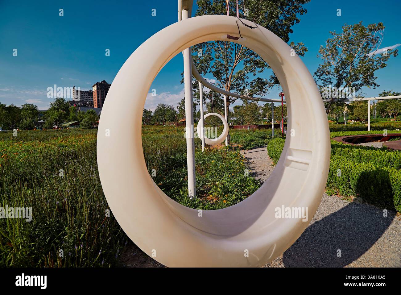 Parco per famiglie con attrezzature da gioco e vegetazione Foto Stock