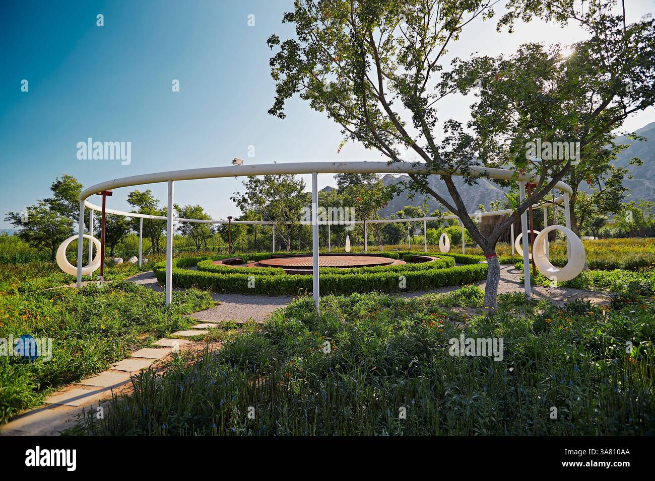 Parco per famiglie con attrezzature da gioco e vegetazione Foto Stock
