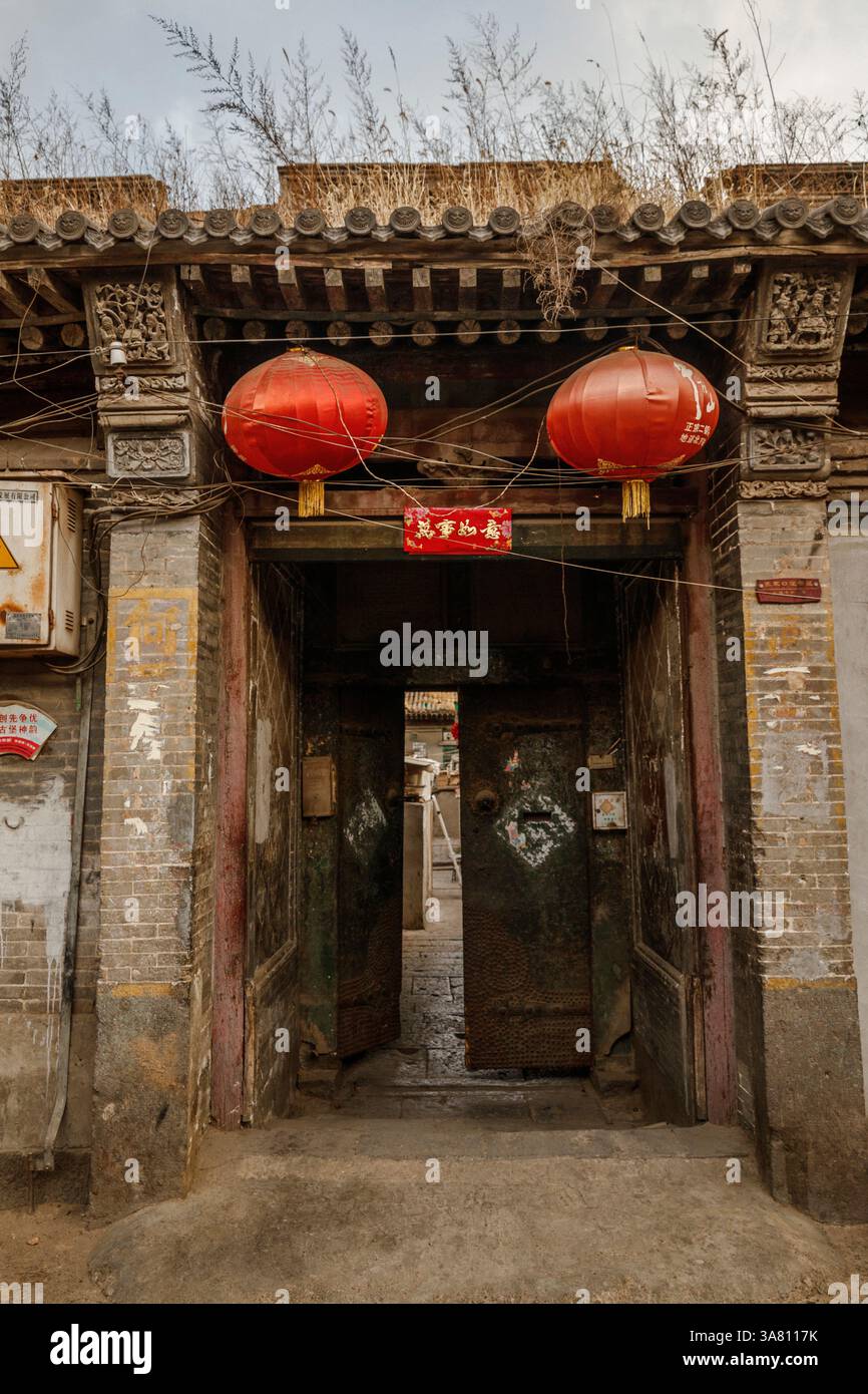 Ingresso Cinese con colonne di pietra e porta di legno Foto Stock