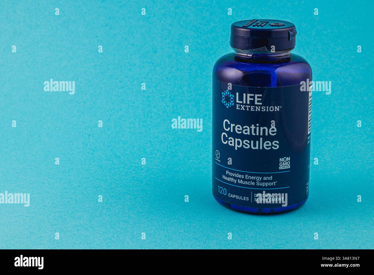 24.03.25 Lviv Ucraina contenitore blu di capsule di creatina si trova su un solido sfondo blu, indicando l'integratore alimentare per energia e muscolo He Foto Stock 24.03.25 Lviv Ucraina contenitore blu di capsule di creatina si trova su un solido sfondo blu, indicando l'integratore alimentare per energia e muscolo He Foto Stock