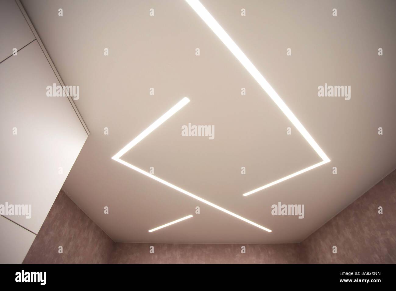 Soffitto allungato moderno ed elegante con linee luminose a LED. Foto Stock